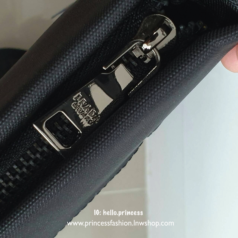 กระเป๋าผู้ชาย อเนกประสงค์ จากแบรนด์ PRADA วัสดุทำจากผ้า POLYESTER กันน้ำอย่างดี ขนาดกำลังดี จุของได้เยอะ ใส่Tabletได้ ใส่สมุดหนังสือได้สบาย โลโก้อะไหล่ลมดำ สวยหรูมากคะรุ่นนี้ อะไหล่สีเงิน มีช่องซิปด้านหลัง ภายในมีช่องซิปและป้ายหนังแบรนด์