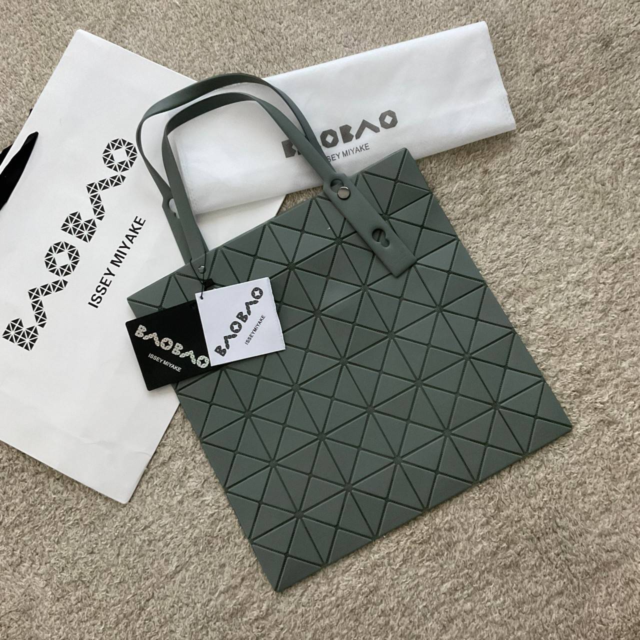 BAO BAO ISSEY MIYAKE LUCENT ONE-TONE กระเป๋าสะพายไหล่ ทรงโท้ท ใบใหญ่สวยมาก ปรับได้หลายทรงตามเอกลักษณ์เฉพาะของแบรนด์นี้ วัสดุ 100% POLYESTER PARTLY: SYMYHETIC LEATHER ด้านในใส่ของได้เยอะมาก ใส่ไอแพด สมุดโน้ตได้สบายเลย วัยทำงานหรือวัยนักศึกษา อย่างน้อยต้องม