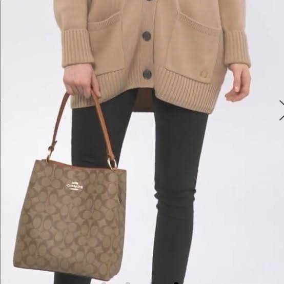 COACH SMALL TOWN BUCKET BAG IN SIGNATURE สำหรับสาวแฟชั่นที่ชอบรายละเอียดชิคๆ ดีไซน์สุดเก๋ แนะนำเลยสำหรับกระเป๋าทรงบักเก็ตใบนี้ เชื่อว่าสาว ๆ หลายคนชื่นชอบ เป็นไอเทมที่สามารถแมทช์ได้กับเสื้อหลากหลายสไตล์ บรรจุของได้เยอะโดยที่กระเป๋าไม่เสียทรง แบ่งช่องใช้งา