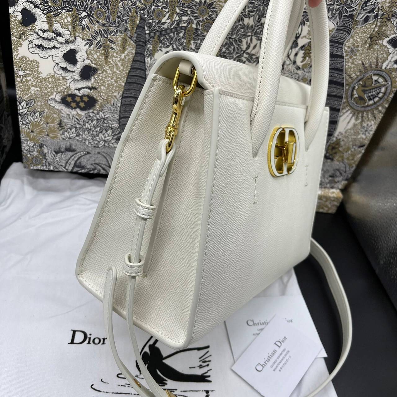 หนังแท้ DIOR Medium ST Honore Tote Collection Fall/Winter 2020-2021 มาในรูปแบบกระเป๋าทรงสี่เหลี่ยมที่ได้มาตรฐาน ทำจากหนังลูกวัว (Calfskin) ลายเกรน ซึ่งสื่อถึงความหรูหราได้อย่างลงตัว ตัวด้ามจับ มีการเย็บเข้าด้านในของกระเป๋าเพื่อเพิ่มความแข็งแรงทนทาน ด้านหน