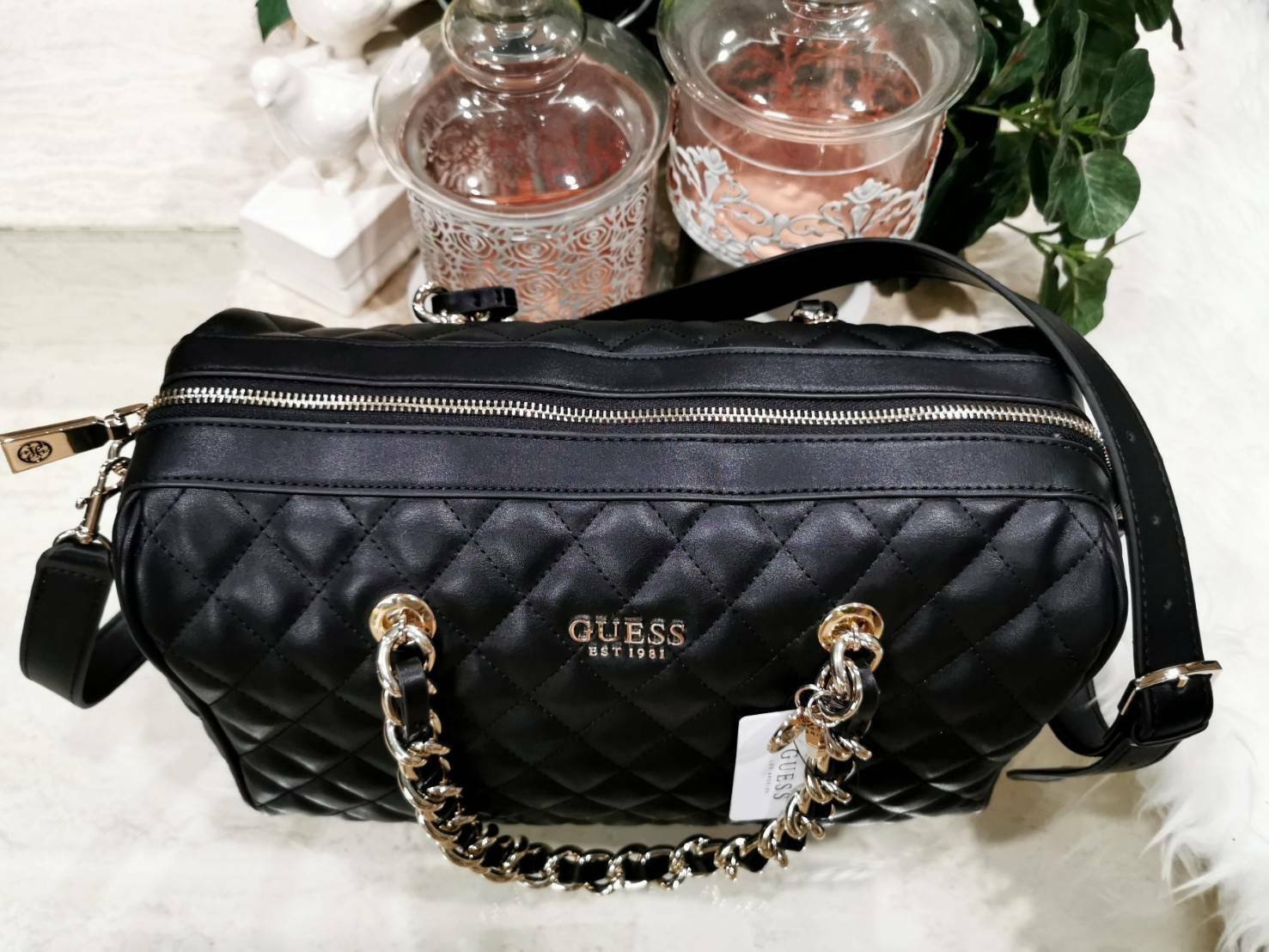 GUESS WOMEN’S BOWLING BAG กระเป๋าสะพายทรง Bowling รุ่นใหม่ล่าสุดจาก GUESS FACTORY หนังนิ่มลายตารางสวยอยู่ทรงใบใหญ่กำลังดี ด้านหน้าประดับโลโก้หูหิ้วโซ่ร้อยหนังสะพายไหล่ได้เเข็งแรงรับน้ำหนักได้เยอะ เปิดปิดด้วยซิปสะดวกใช้ มีหมุดรองฐานกันรอย ภายในมีช่องซิปและ