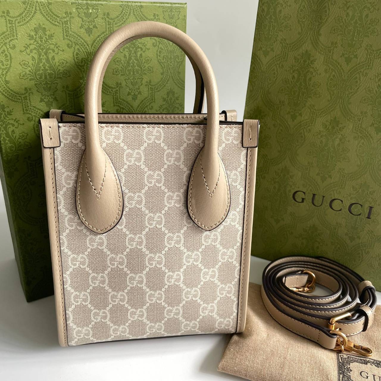 หนังแท้ GUCCI Mini tote bag with Interlocking G พร้อมส่งที่ไทย Beige and white GG Supreme canvas เกรดออริจินอล ภาพสินค้าถ่ายจากงานขายจริง ใช้งานต่างประเทศได้ The mini tote bag is complete with an oatmeal leather trim and an Interlocking G tag.