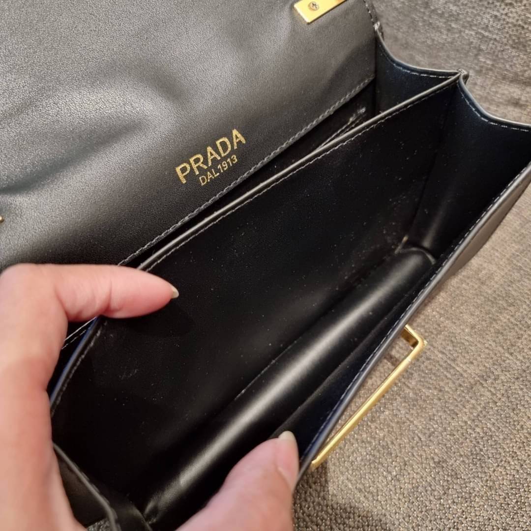 PRADA FRAGRANCE SHOULDER BAG WITH GWP ไอเท็มสุดโปรดที่ควรค่าแก่การครอบครองและเก็บสะสม กระเป๋าสะพายไหล่ สวยคม สีดำคลาสสิคตัดกับอะไหล่ทองเป็นอย่างดี วัสดุหนังแท้เต็มใบ เปิดปิดด้วยแถบหนังสอดในช่อง ใช้งานสะดวก พกพาง่าย ขนาดกำลังสวย สายสะพายในตัว สะพายได้หลากห