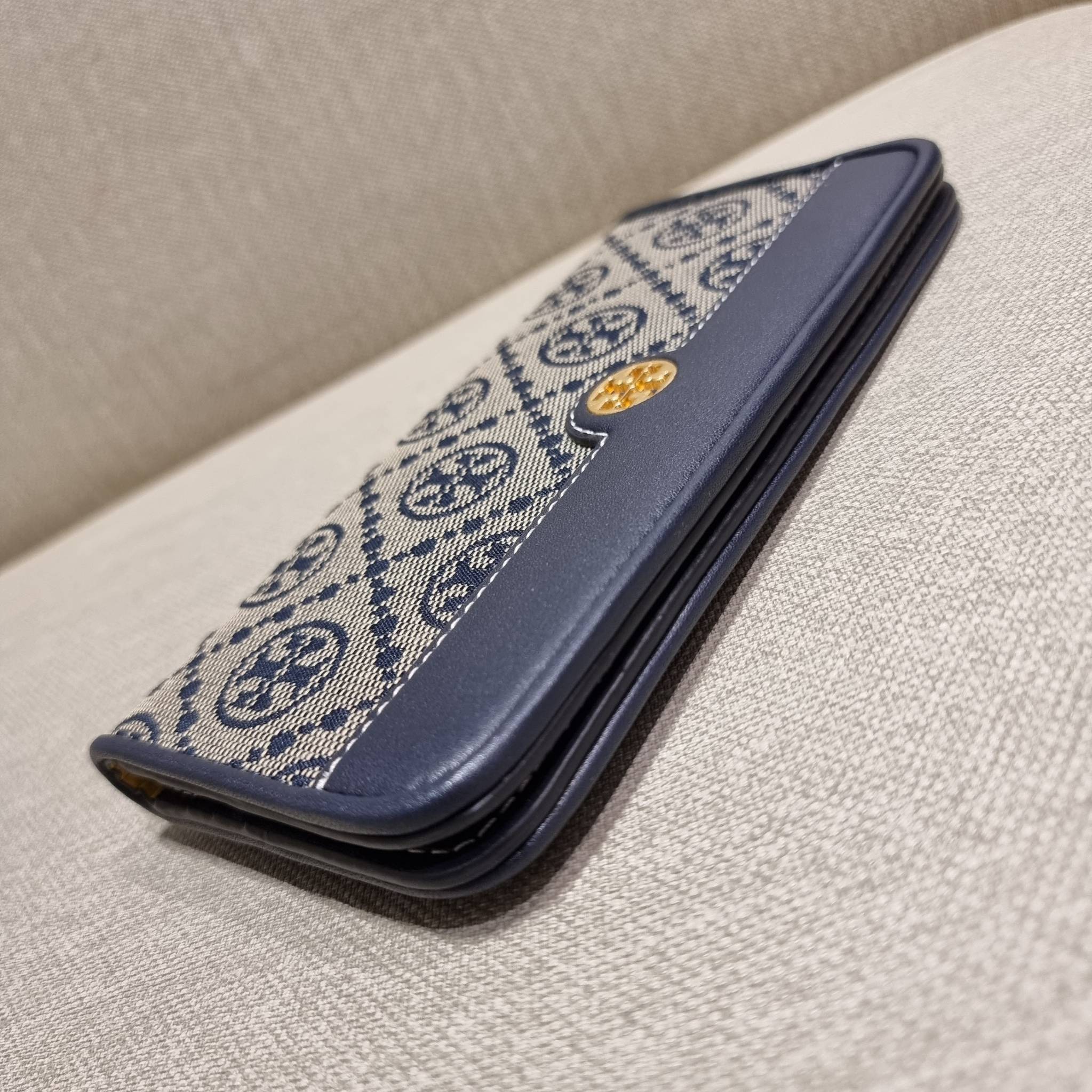 TORY BURCH T MONOGRAM JACQUARD SLIM WALLET ของดีมีให้ที่นี่แบบจัดเต็ม กระเป๋าสตางค์ใบยาว รุ่นสลิม สวยหรู ขนาดกำลังเหมาะมือ ถือแล้วขับผิว วัสดุผ้า jacquard ตัดสลับหนังแท้ ภายในสวยคมม้าก!! มีช่องใส่บัตรได้แบบเน้นๆ และช่องใส่ธนบัตรได้ ด้านหลังมีช่องซิปอีกหนึ