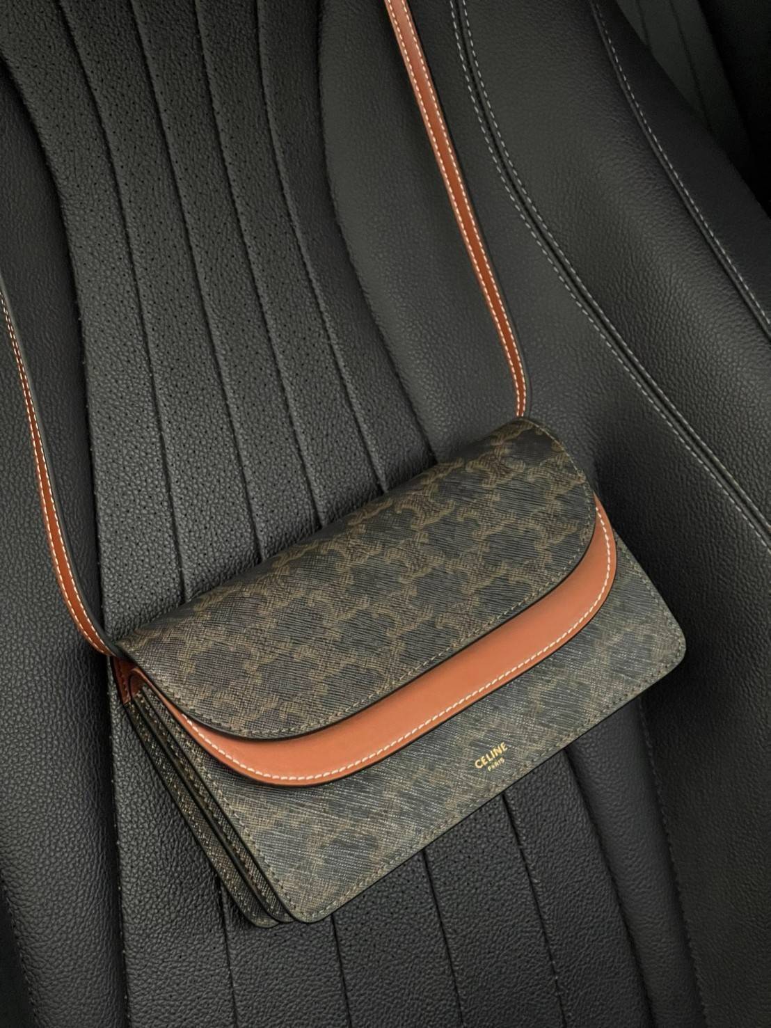 CELINE WALLET ON STRAP IN TRIOMPHE CANVAS กระเป๋าสะพายไหล่สุดเก๋ใบนี้ผลิตจากผ้าใบเคลือบอย่างดีพร้อมขอบหนังสีน้ำตาล กระเป๋ามีสายสะพายหนังสีน้ำตาลพร้อมฮาร์ดแวร์สีทอง ถอดสายออกเพื่อเป็นกระเป๋าถือทรงคลัชท์เปลี่ยนลุคช์ ลวดลายtriomphe ความเป็นแบรนด์ CELINE ได้อ