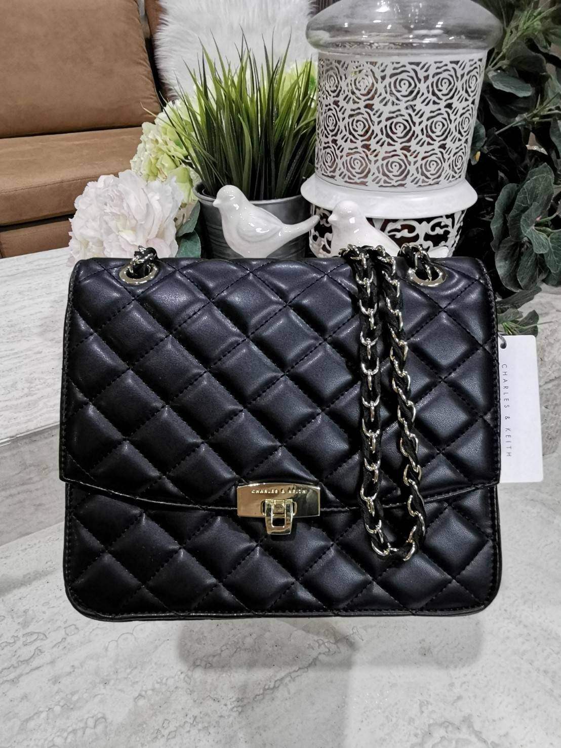 CHARLES & KIETH DETAIL CROSSBODY BAG กระเป๋าสะพายทรงเหลี่ยมดีไซน์สวยหรูคลาสสิควัสดุหนังนิ่มลายตารางอยู่ทรงสไตล์ Chanel เปิดปิดด้วยตัวล๊อคแบบพับอะไหล่ทองปั้มโลโก้ด้านหน้าสวยดูดี พร้อมสายสะพายโซ่ร้อยหนังสามารถสะพายไหล่หรือ Crossbody ก็ดูดี ภายในมีโลโก้และหน