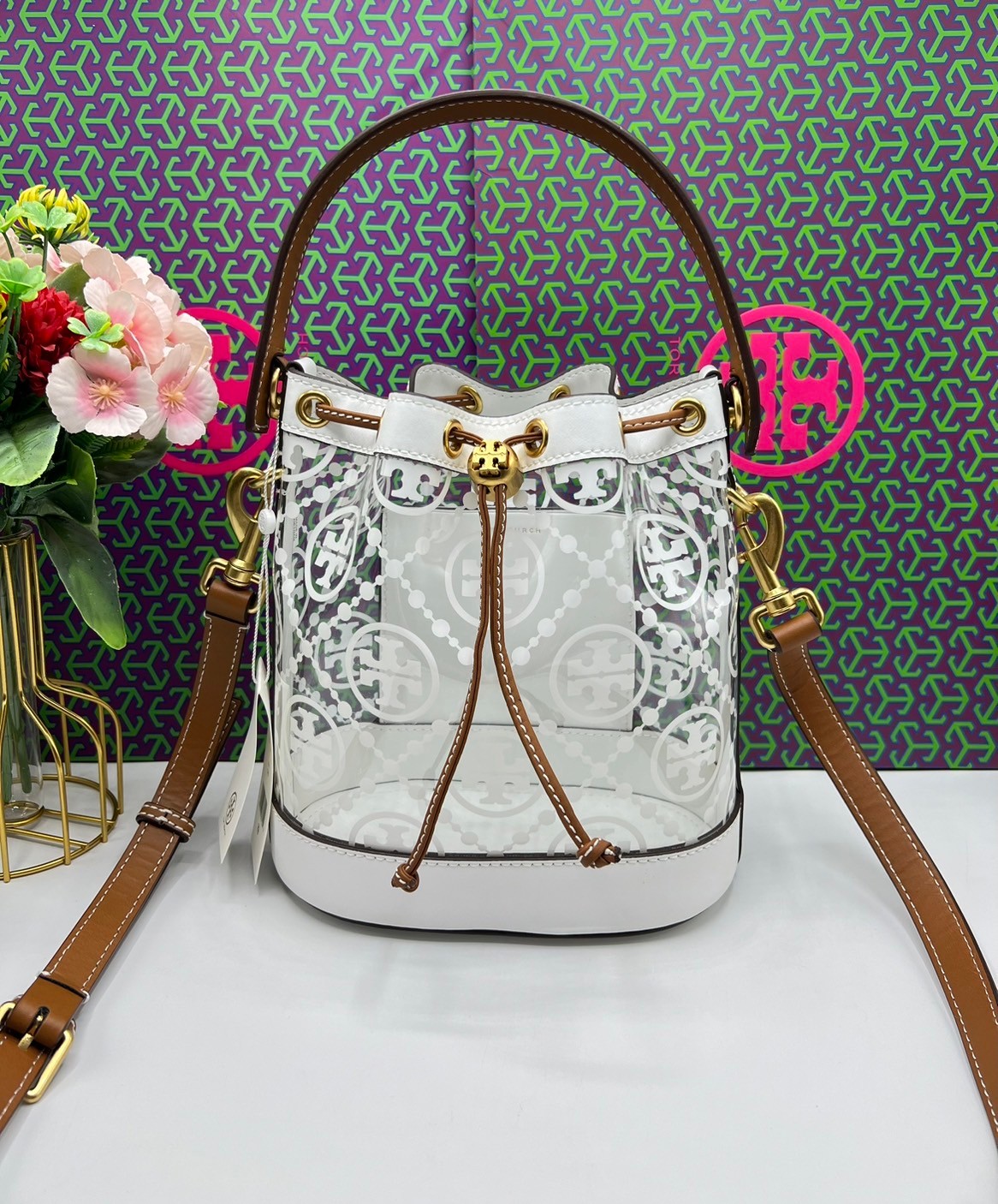 Tory Burch T Monogram Clear Bucket Bag / Tory Clear Bucket Bag ใหม่ล่าสุด กับกระเป๋าบัคเก็ต สีขาวสวยสะอาดตา ดีไซน์โปร่งละมุนมากๆ ดดเด่นด้วยลวดลายเอกลักษณ์ คมชัด ใช้งานง่ายด้วยการรูดหนังเปิด-ปิดที่ปากกระเป๋า ภายในเป็นช่องโล่ง งานจริงสวยน่าใช้มากค่ะ