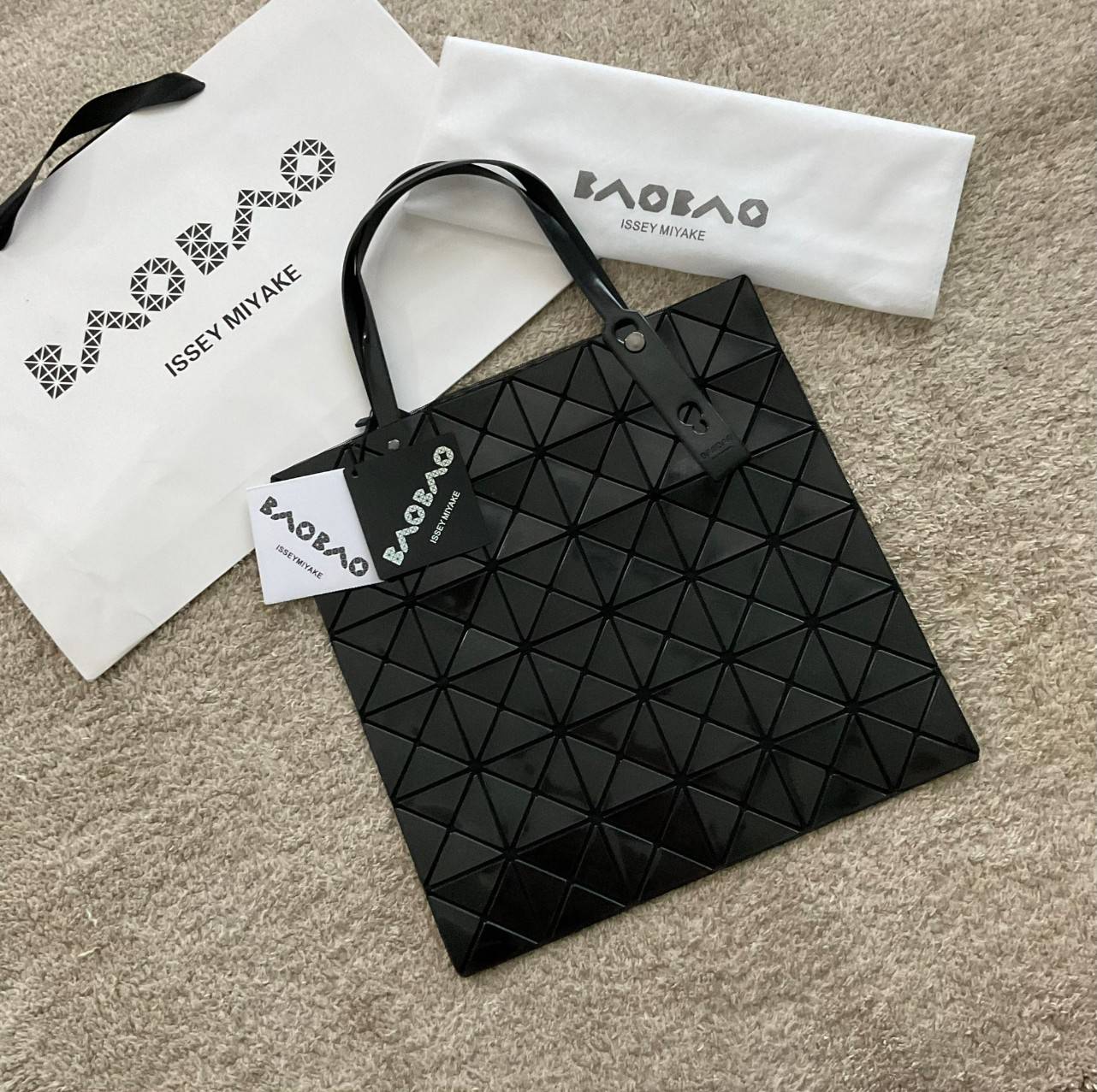 BAO BAO ISSEY MIYAKE TOTE BAG (6x6) กระเป๋าสะพายไหล่ ใบใหญ่ ทรงโท้ท จุดเด่นคือ ปรับได้หลายทรงตามเอกลักษณ์เฉพาะของแบรนด์นี้ ด้านในใส่ของได้เยอะมาก ใส่ไอแพด สมุดโน้ตได้สบายเลย พร้อมช่องซิปใส่ของให้อีกหนึ่งช่อง วัยทำงานหรือวัยนักศึกษา อย่างน้อยต้องมีแบรนด์นี