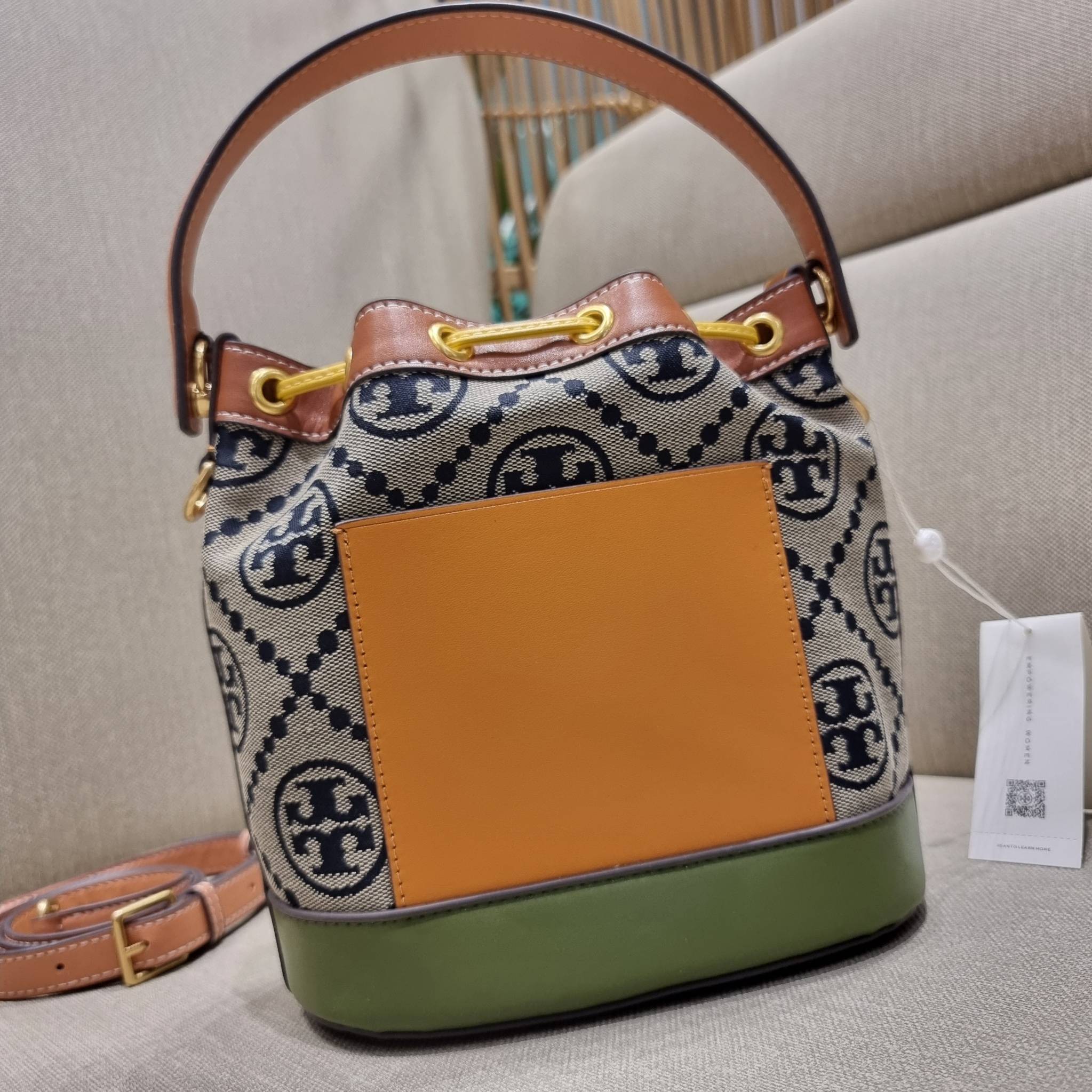 TORY BURCH T MONOGRAM COLORBLOCK JACQUARD BUCKET BAG ไอเท็มใหม่ที่ใครๆก็รอ กระเป๋าบัคเก็ตทรงสวย ที่ยังคงให้ความโดดเด่นด้วยลวดลายเอกลักษณ์ เพิ่มเติมดีไซน์บล็อคสี ตัดกันได้อย่างลงตัว ถักทอบนวัสดุ woven jacquard ลายคมชัด สลับส่วนของหนังแท้ ภายในเป็นช่องโล่งก