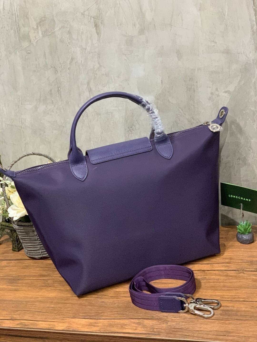 Longchamp Le Pliage Neo Size M มาพบกับกระเป๋ารุ่นยอดนิยม ที่สาวๆ ต้องมีไว้เก็บไว้สักใบ กระเป๋าโท้ทใบนี้ มาพร้อมกับสีที่มีสไตล์เรียบง่าย มีสายสะพายยาวช่วยให้คุณสามารถสะพายไหล่ได้อย่างสบาย ในขณะที่ที่ปิดแบบซิปช่วยให้คุณมั่นใจได้ว่าของด้านในมีความปลอดภัย Le 
