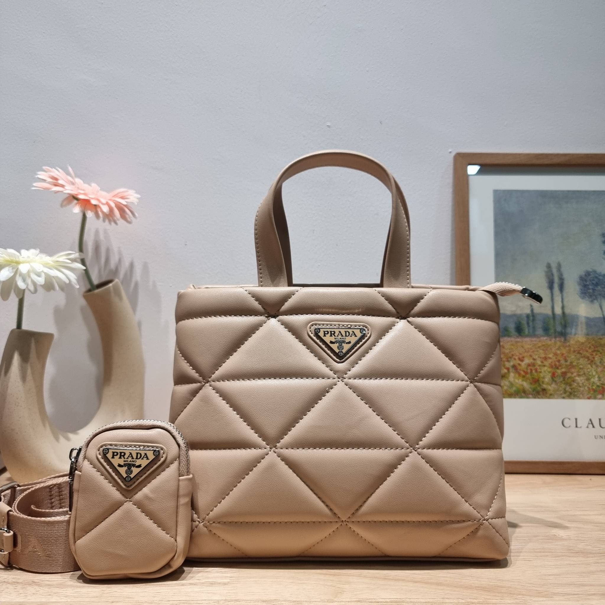 PRADA LEATHER PADDED BAG ใหม่ล่าสุด กับคอลเลคชั่นที่ทำออกมาตอบโจทย์ได้ทุกไลฟ์สไตล์ และเป็นยูนิเซ็กส์ กับกระเป๋าทรงโท้ท ขนาดกำลังดี วัสดุหนังเรียบ ตัดเย็บเดินเส้นลายตาราง ปากกระเป๋ามีซิปเปิดปิด ภายในเป็นช่องโล่ง