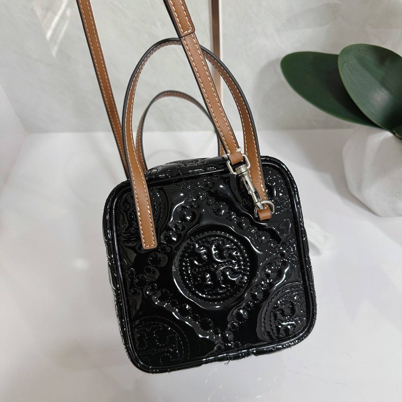 Tory Burch T Monogram Embroidered Patent Cube คอลเลคชั่นใหม่ รุ่นลิมิเต็ดรูปทรงใหม่ T Monogram สุดcube วัสดุหนังแท้ เปิด-ปิดด้วยซิป ภายในกว้าง มีช่องแยก 1 ช่อง สามารถใส่โทรศัพท์มือถือได้ทุกรุ่น สามารถถือหิ้วหรือสะพายได้ สายสามารถถอดและปรับระดับได้คะ