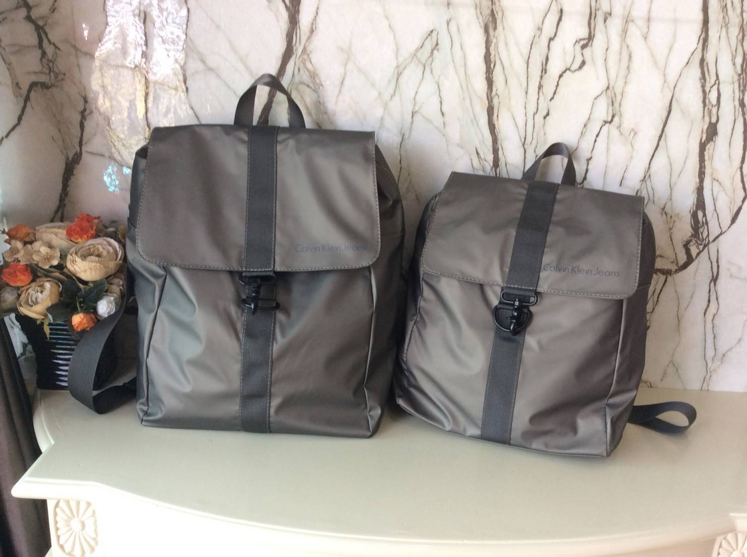 CALVIN KLEIN JEANS NYLON BACKPACK กระเป๋าสะพายเป้มี 2 size ให้เลือกตามการใช้งาน วัสดุ Nylon + Polyester 100% น้ำหนักเบา กันน้ำปานกลาง ด้านหน้าสกรีนโลโก้ Calvin Klein Jeans เปิดปิด 2 ชั้น ด้วยตัวล็อค เเละซิปเดียวด้าน ภายในกว้าง ใส่ A4, iPad หรือเสื้อผ้าได้