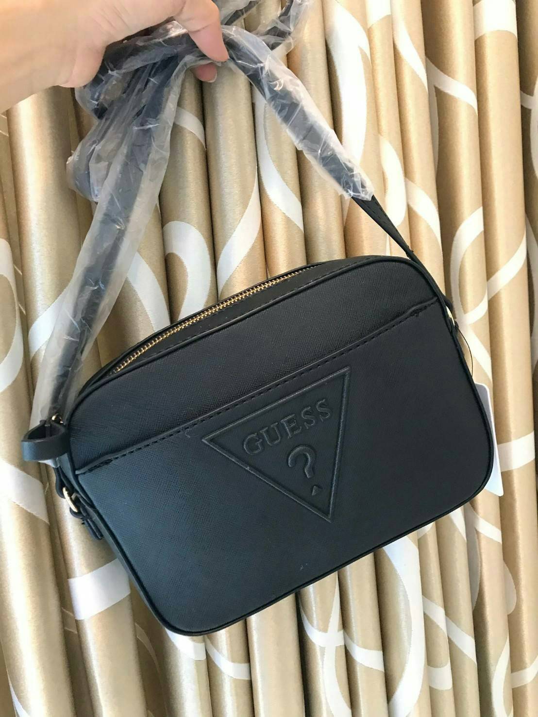 GUESS CROSSBODY BAG กระเป๋าสะพายรุ่นใหม่ ทรงเหลี่ยมตั้งอยู่ทรง วัสดุหนังSaffiano ด้านหน้าปั้มลายโลโก้นูน เปิดปิดด้วยซิปเดียวด้านบน ภายในกว้างใส่กระเป๋าสตางค์ใบยาวได้ ด้านหน้ามีช่องเล็ก1ช่อง ภายในมีช่องซิปเล็ก1ช่อง แยกเป็นสัดส่วน ด้านในบุผ้าลายสกรีน น้ำหนั