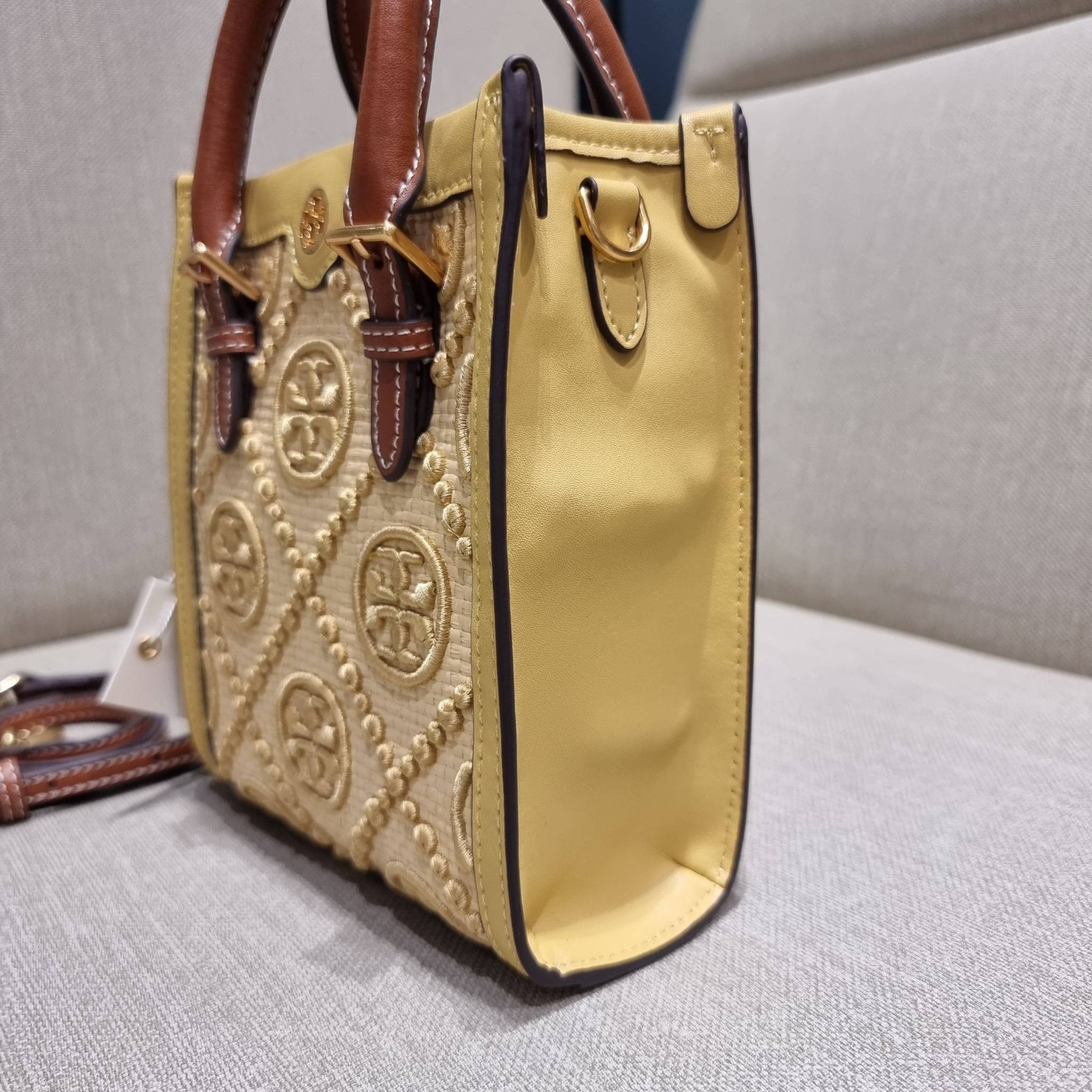 TORY BURCH T MONOGRAM STRAW MINI TOTE สวยสุด ดูแพงสุด!! ต้องยกให้เลย กับไอเท็มนี้ กระเป๋าสะพายทรงโท้ท ไซส์มินิ มีลูกเล่นที่ดีเทลเยอะมาก ด้วยงานฝีมือปักสานด้วยวัสดุจากกธรรมชาติ ถักทอเป็นลายเส้นขึ้นลายนูน ตัดขอบด้วยหนังแท้ และยังโดดเด่นด้วยหูจับในตัวโทนสีอุ