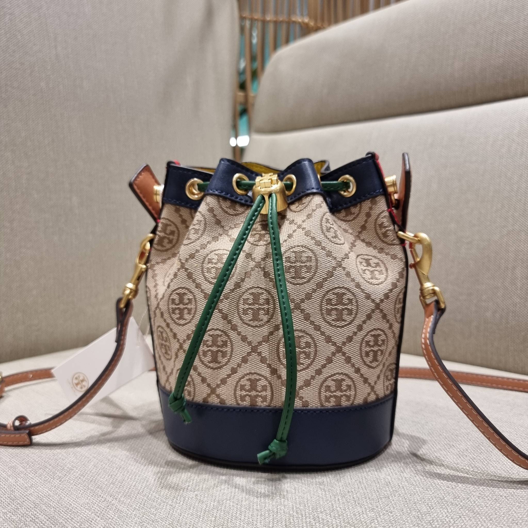 MINI : TORY BURCH T MONOGRAM COLOR-BLOCK JACQUARD MINI BUCKET BAG ใหม่ล่าสุด กับกระเป๋าบัคเก็ตทรงสวย ไซส์มินิ ในราคาน่ารัก โดดเด่นด้วยลวดลายเอกลักษณ์ ผสานลายคัลเลอร์บล็อค โทนสีตัดกันอย่างลงตัว ถักทอบนวัสดุ woven jacquard ลายคมชัด สลับส่วนของหนังแท้ ภายในเ