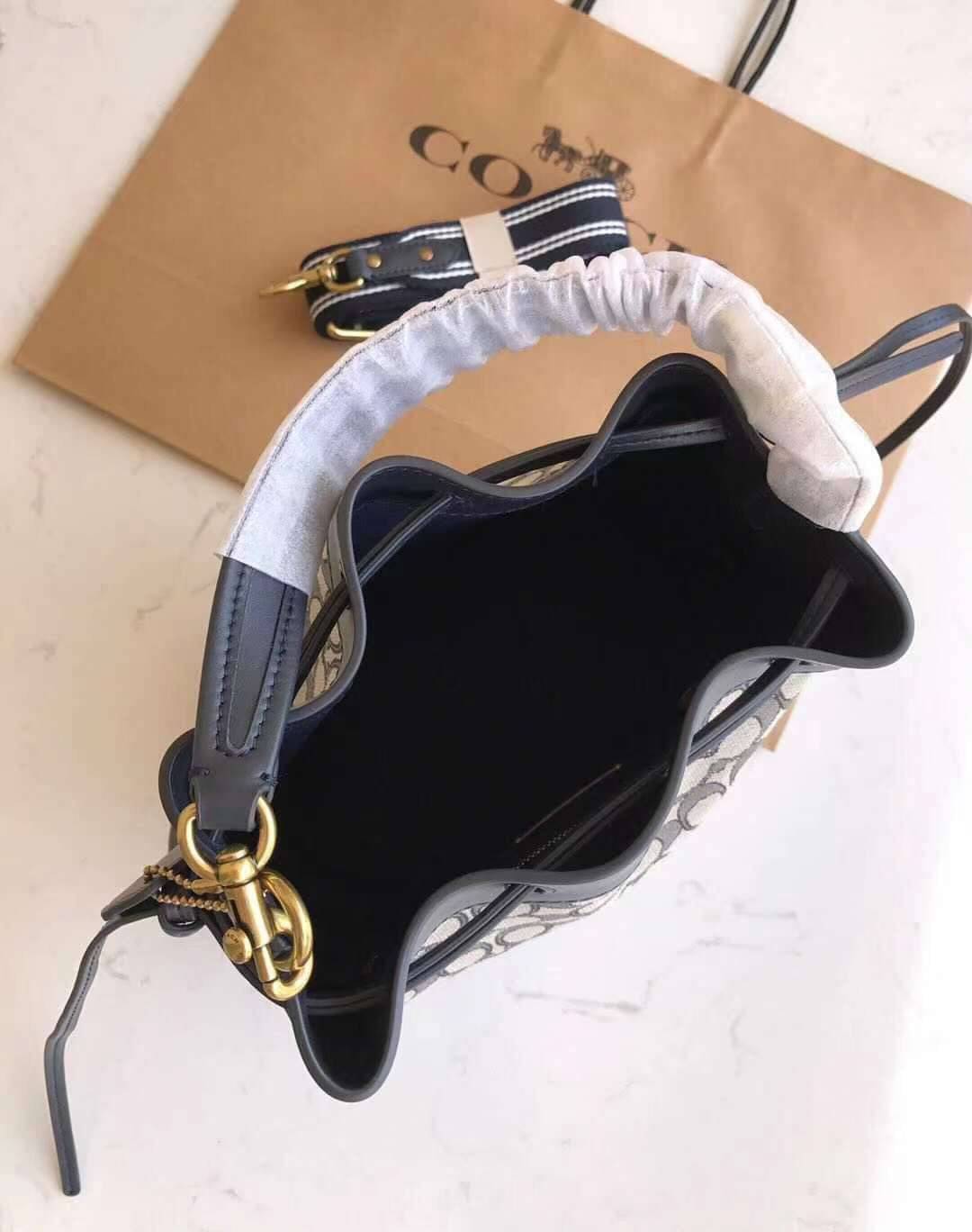 COACH FIELD BUCKET BAG IN SIGNATURE JACQUARD C3853 กระเป๋าสะพายทรงบัคเก็ต รุ่นใหม่ล่าสุด ดีไซน์ลายซิกเนเจอร์บนผ้า jacquard สวยคม เป็นเอกลักษณ์ไม่ซ้ำใคร มาพร้อมสายสะพายผ้าสปอร์ต และสายสั้นสำหรับคล้องแขนได้ สามารถรูดปิดปากกระเป๋าด้วยหนังรอบใบ เพิ่มดีเทลให้ต