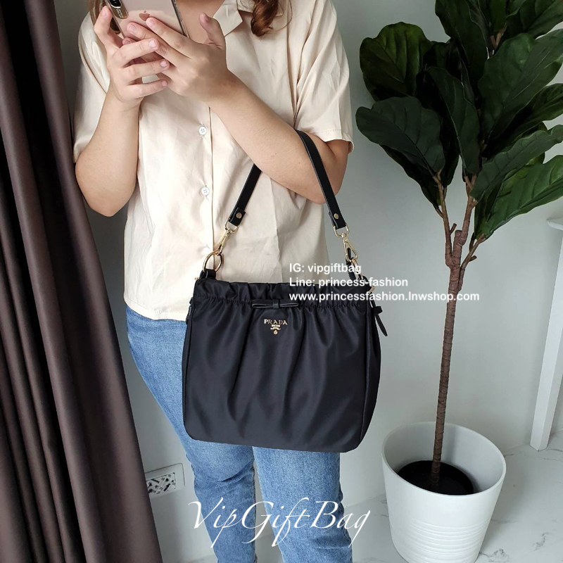 Prada nylon รุ่น Limited edition **กระเป๋าทรงน่ารัก จับจีบปากกระเป๋า ดีมาก วัสดุผ้าNyonกันน้ำ ตามแบบฉบับแบรนด์ เปิด/ปิดด้วยซิป ภายในเย็บติดป้ายหนังแบรนด์ มีช่องซิปเล็ก1 สามารถใส่ของจุกกจิกได้ สามารถใส่IPad mimiได้ มีช่องซิปเล็ก1ช่อง มาพร้อมสายหนังสั้นคล้อ