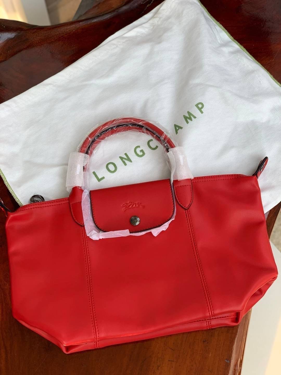 Longchamp LE PLIAGE CUIR TOP HANDLE BAG S เรียกว่าเป็นกระเป๋าอีกหนึ่งรุ่นที่ไม่ว่ายังไงก็ฮอตฮิตและติดเทรนด์ตลอดไม่เคยเปลี่ยนกับ ทรง Le Pliage Cuir หนึ่งในตระกูลกระเป๋าสุดไอคอนิกจากแบรนด์ เมื่อรุ่น Le Pliage Cuir ในรูปแบบของหนังแกะ Metis ได้ถือกำเนิดขึ้นใน