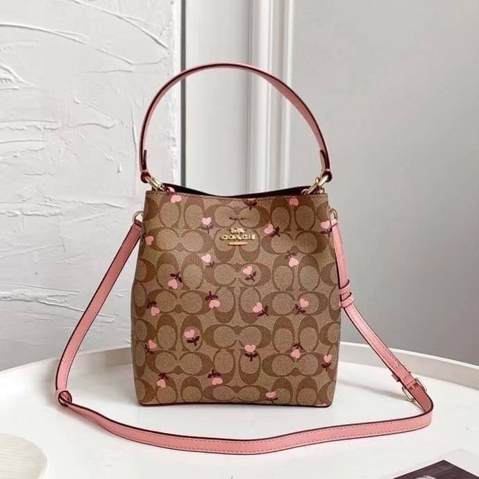 OUTTLET 】COACH SMALL TOWN BUCKET BAG IN SIGNATURE WITH Heart floral print สำหรับสาวแฟชั่นที่ชอบรายละเอียดชิคๆ ดีไซน์สุดเก๋ แนะนำเลยสำหรับกระเป๋าทรงบักเก็ตใบนี้ เชื่อว่าสาว ๆ หลายคนชื่นชอบ เป็นไอเทมที่สามารถแมทช์ได้กับเสื้อหลากหลายสไตล์ บรรจุของได้เยอะโดยท
