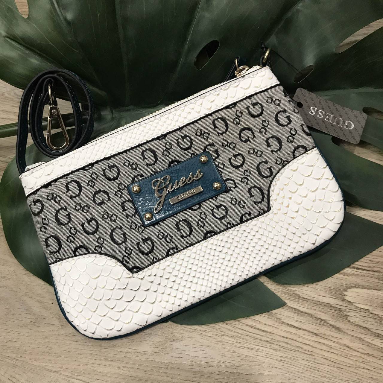 DON'T MISS! GUESS WOMEN'S CLUTH BAG กระเป๋าคลัชพร้อมสายคล้องรุ่นแนะนำโดดเด่นด้วย Signature ลาย G สวยอยู่ทรง เปิดปิดด้วยซิปสะดวกใช้ ด้านหน้าประดับโลโก้ มาพร้อมสายคล้องมือถอดได้ ภายในมีโลโก้และช่องใส่บัตรสามารถใส่ธนบัตรแบงก์พัน บัตรเครดิต iphone8+