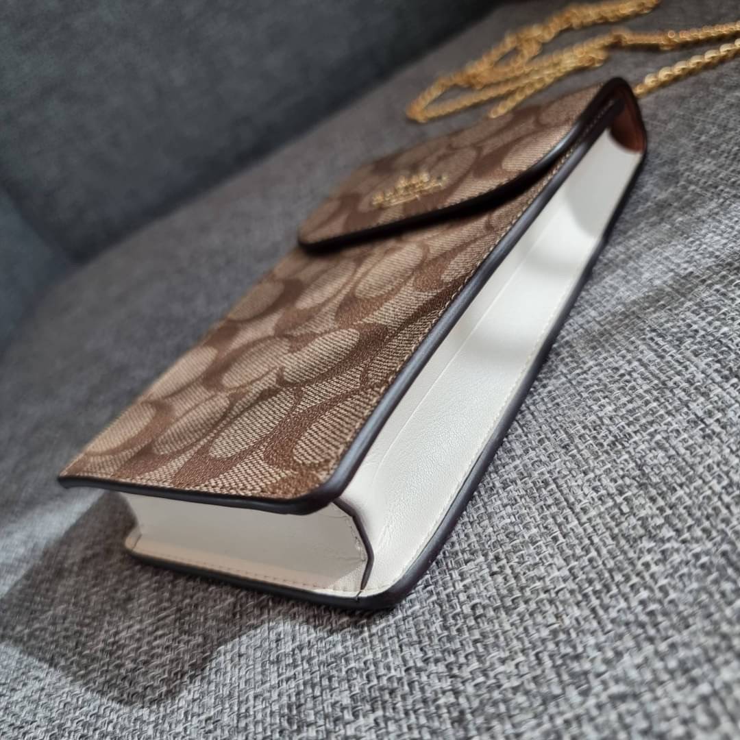 COACH NORTH/SOUTH PHONE CROSSBODY IN SIGNATURE CANVAS F55636 F39955 สุดคลาสสิคกับกระเป๋าสะพายเอนกประสงค์ Case phone ใส่โทรศัพท์มือถือได้ทุกรุ่น ดีไซน์ลายเอกลักษณ์ วัสดุหนังแคนวาสเคลือบลาย ฝาและภายในเป็นหนังสังเคราะห์เรียบ เปิด-ปิดด้วยกระดุม สายสะพายยาวประ