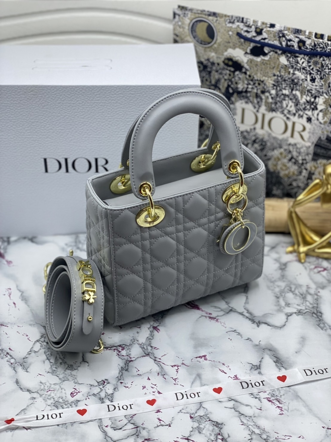 หนังแท้ DIOR LADY BAG 20cm ความสง่างามอีกหนึ่งรุ่นของ Dior รูปทรงสีเหลียม ขนาดกระทัดรัด ตั้งอยู่ทรง ฐานกระเป๋าแข็งแรง มีหมุดรองฐาน ดีไซน์ที่มีเอกลักษณ์เฉพาะตัว ด้านหน้าตกแต่งด้วยตัวอักษร D.I.R ห้อยเป็นพวงกุญแจ จะถือด้วยมือหรือสะพายไหล่ก็ดูดีมากๆ ค่ะ