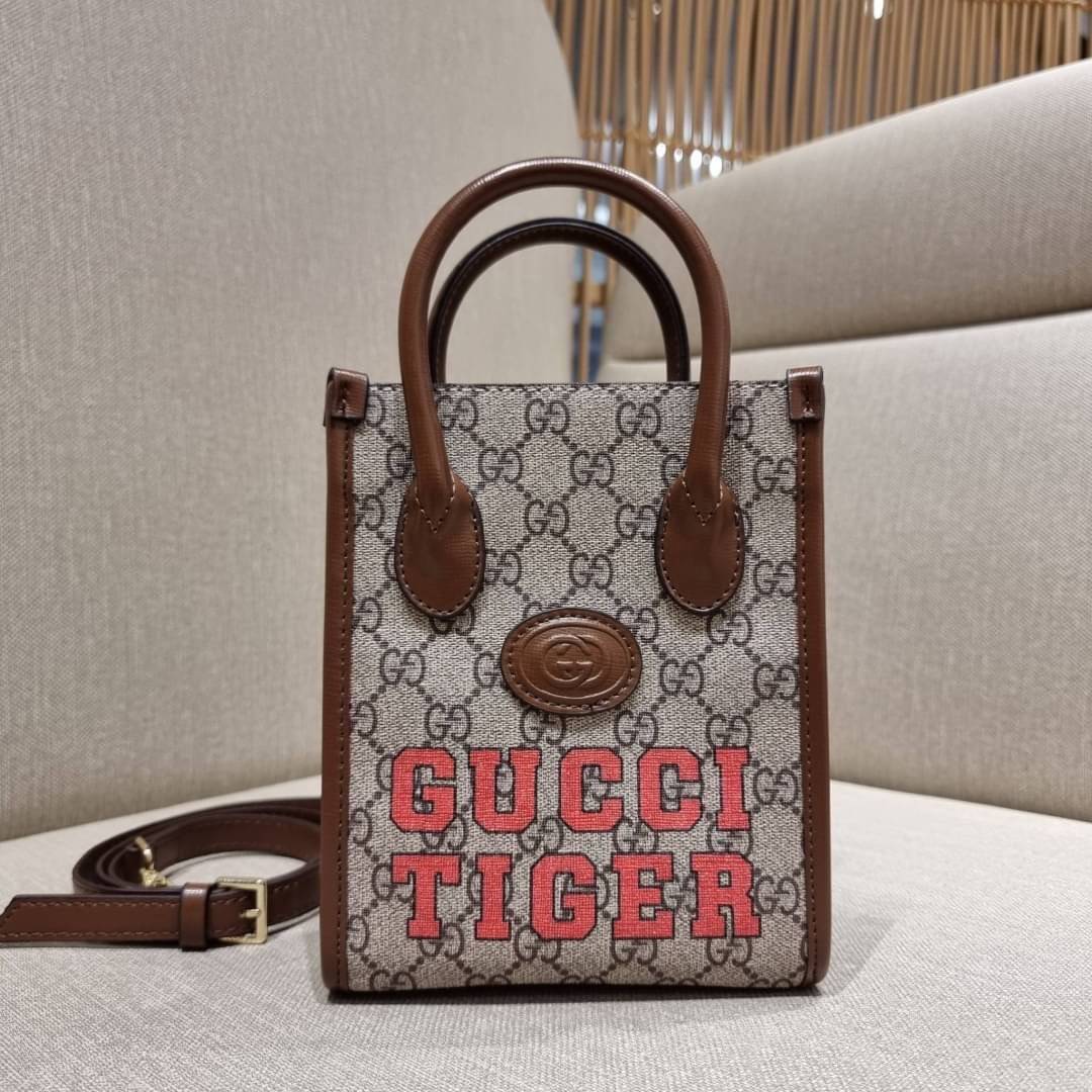 GUCCI Tiger GG mini tote bag ไซส์มินิ ร้อนแรงไฟลุก!! ต้อนรับปีเสืออย่างเป็นทางการ จัดให้แบบเลิศๆ กับกระเป๋าทรงโท้ท วีไอพีพรีเมี่ยมกิ๊ฟ ไซส์มินิ โดดเด่นด้วยฟอนท์ตัวใหญ่ สวยเอกลักษณ์ วัสดุหนังแคนวาสตัดขอบด้วยหนังแท้ ภายในเป็นช่องโล่ง ใส่ของจุกจิกได้ ใส่โทรศ
