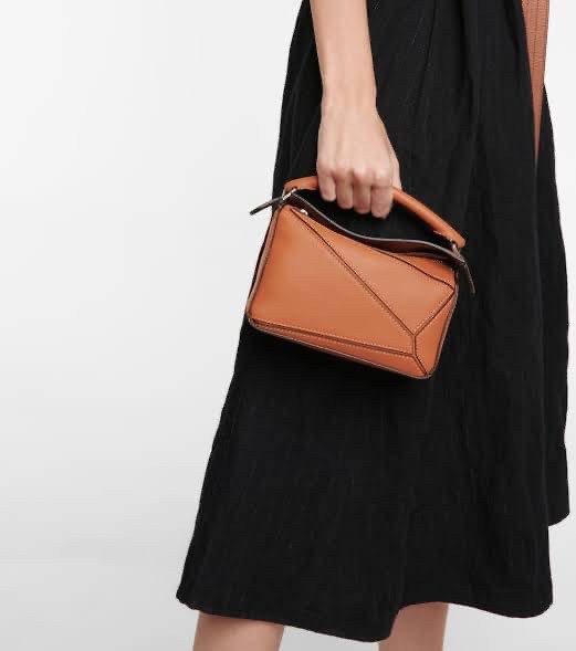 Loewe Nano Puzzle bag in classic โลเอเว่ (LOEWE) อีกหนึ่งกระเป๋าแบรนด์ดังจากสเปน ภายใต้คอลเลคชั่นใหม่อันร่วมสมัยของแบรนด์ มีความเป็นคลาสสิคและโมเดิร์นทันสมัย กระเป๋าที่มาในรูปแบบสี่เหลี่ยมผืนผ้า ที่สามารถใช้งานได้ทั้งแบบหูหิ้ว และแบบ Crossbody ด้านในมีช่อ