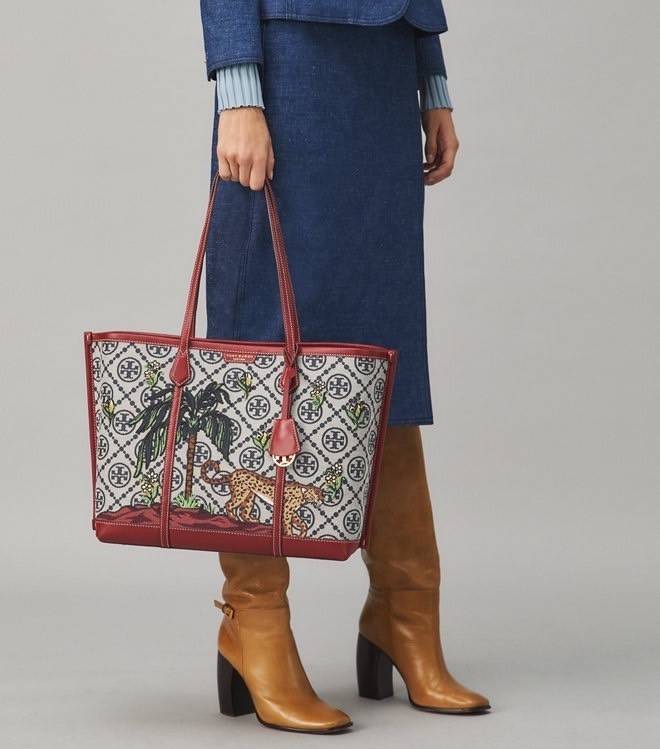 Tory Perry Embroidered T Monogram Triple Compartment Tote Bag เป็นแพทเทิร์นที่ได้รับแรงบันดาลใจจากการควิลท์สไตล์เพนซิลเวเนียดัตซ์ดั้งเดิมและเฉลิมฉลองโลโก้อันเป็นสัญลักษณ์ของแบรนด์ วัสดุผ้าแจ็คการ์ดแบบทอหนัง อะไหล่ทอง โดดเด่นด้วยลายเสือชีร์ต้าร์ งานเย็บปัก