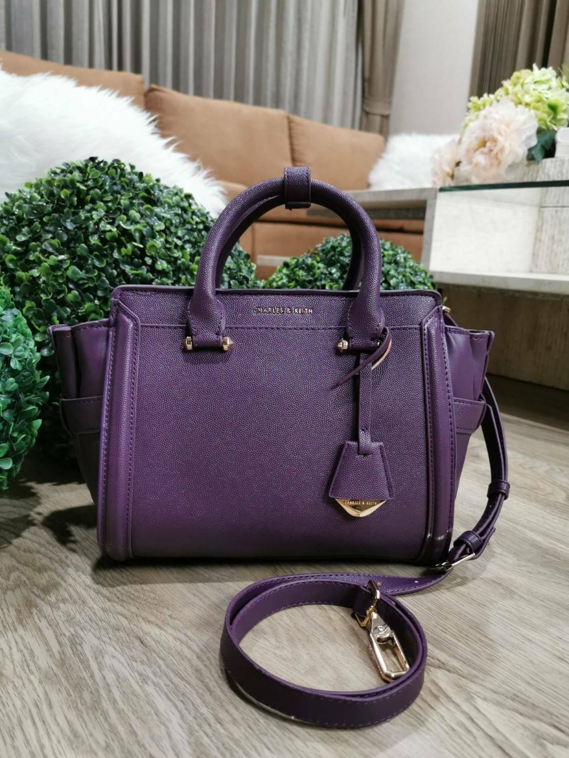 CHARLES & KEITH SAFFIANO TRAPEZE BAG กระเป๋าถือหรือสะพายรุ่นยอดนิยมดีไซน์สวยหรูวัสดุหนังคาเวียร์อยู่ทรง ด้านข้างเเต่งหนังช่องตัดดูมีดีเทล ด้านหน้ามีโลโก้ ด้านหลังมีช่องซิป เปิดปิดด้วยซิปหัวซิปแบรนด์ หูจับเเข็งแรง พับลงได้ พร้อมสายสะพายหนังปรับระดับได้ถอดไ