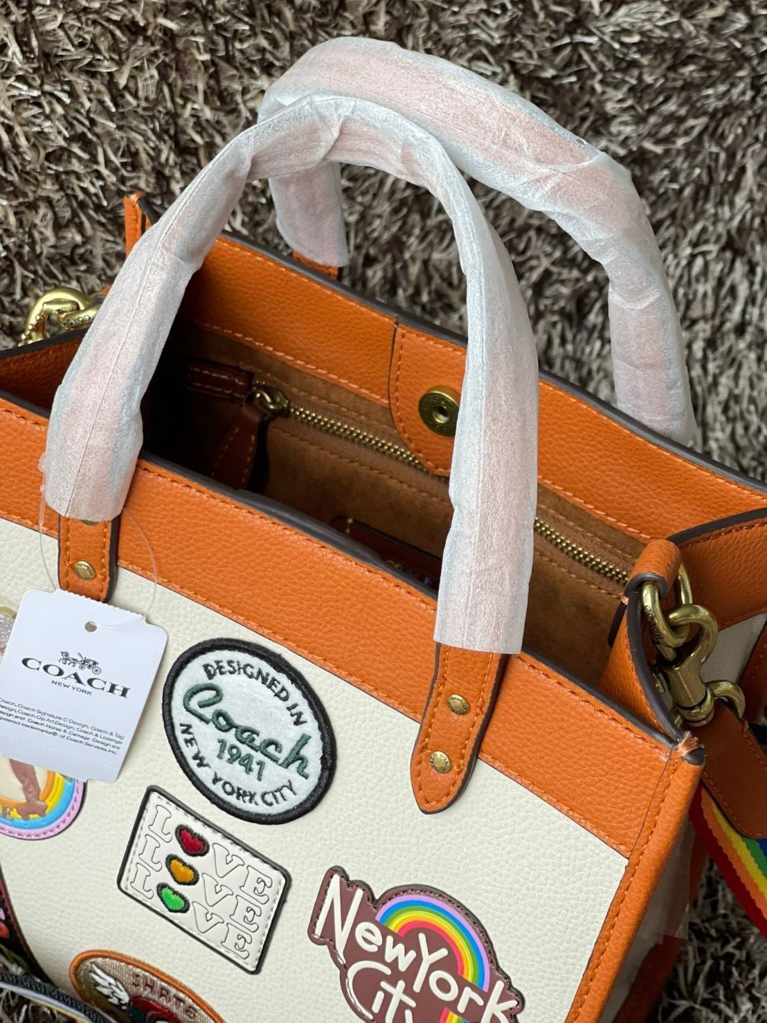 COACH FIELD TOTE 22 WITH PATCHES CA138 ส่วนหนึ่งจาก Coach Pride Collection ซึ่งเป็นการเฉลิมฉลองความเท่าเทียม ความหลากหลาย และการแสดงออกถึงตัวตนที่แท้จริงภายในชุมชน LGBTQIA+ ในเดือนนี้และทุกเดือน ตั้งแต่วันธรรมดาที่วุ่นวายไปจนถึงวันหยุดสุดสัปดาห์ที่เต็มไปด