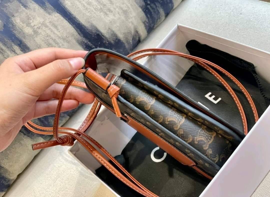 Celine Phone Pouch in Triomphe Canvas and Calfskin Tan / Celine phone bag กระเป๋าใส่โทรศัพท์เรียบหรู ด้วยลวดลาย Triompe ที่แสดงถึงความเป็นเอกลักษณ์ของแบรนด์ ช่องหลักที่มีความกว้าง สามารถใส่โทรศัพท์มือถือ ธนบัตร บัตรต่าง ๆ และของจุกจิกชิ้นเล็ก ๆ ได้แบบจุใจ