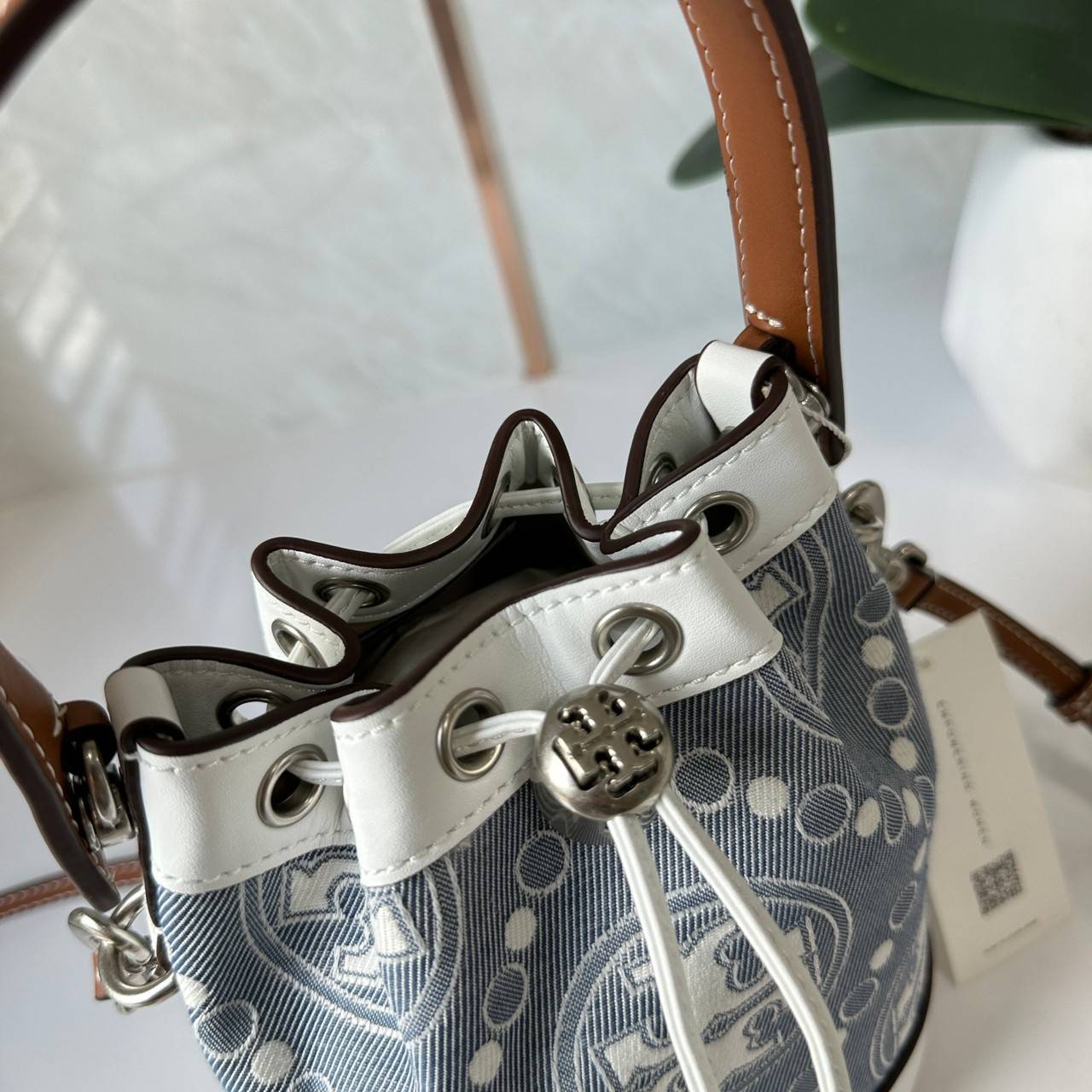 TORY BURCH Mini T Monogram Denim Bucket Bag คอลเลคชั่นใหม่ รูปแบบคลาสสิค พกพาความหรูหราไปได้ทุกที่ด้วยกระเป๋าทรง Bucket ขนาดกลางและปิดด้วยเชือกรูดพร้อมโลโก้แวววาว วัสดุผ้าเดนิมแจ็คการ์ด ตัดขอบหนังแท้ สวยหรู ทันสมัยสุดๆคะ