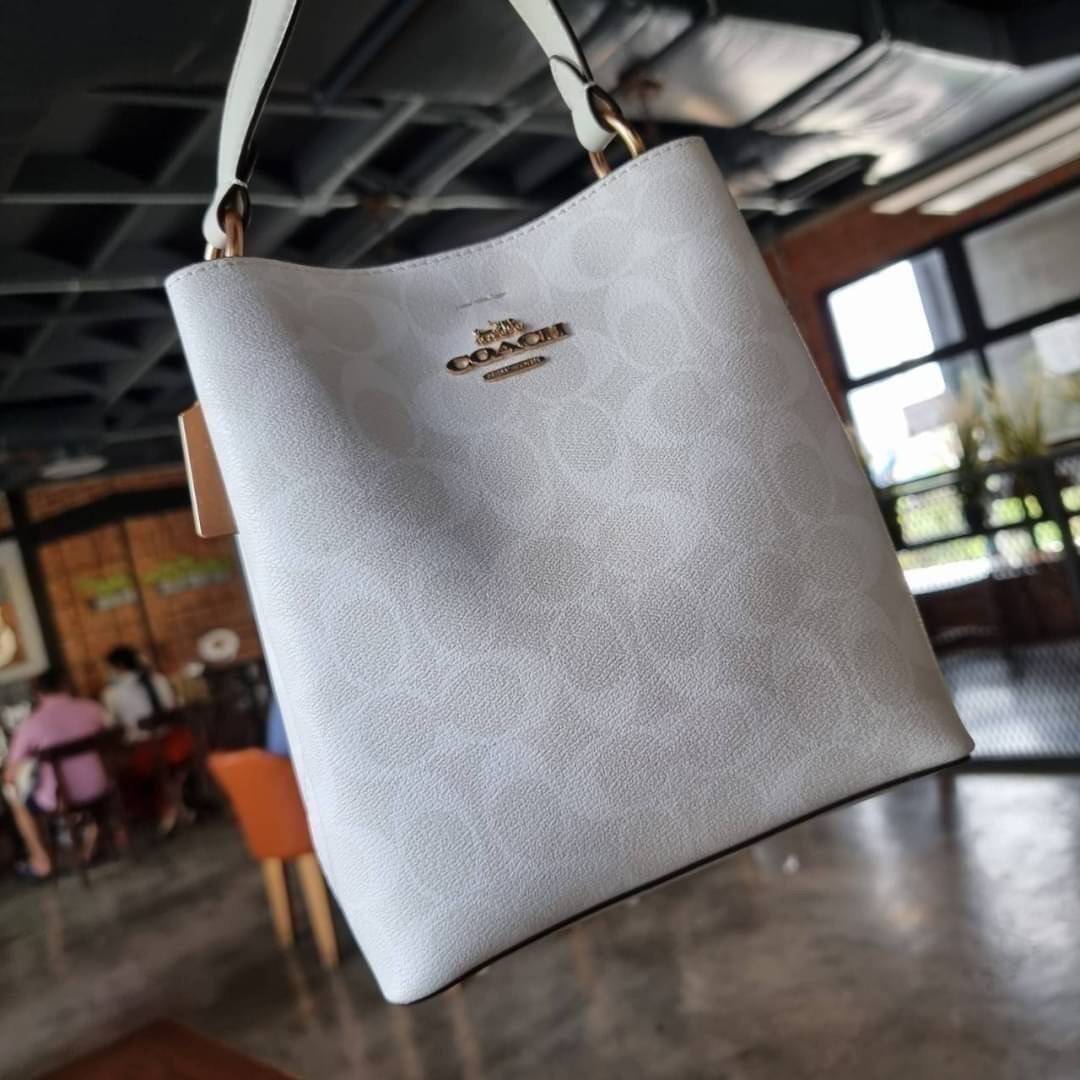 COACH 2312 SMALL TOWN BUCKET BAG IN SIGNATURE CANVAS รุ่นยอดนิยมใบเล็กมาครบสีแล้วจ้า กระเป๋าทรงบัคเก็ต สีผู้ดี๊ผู้ดี ตัวกระเป๋าดีไซน์คลาสสิคลายซี ดูโดดเด่น วัสดุหนังแคนวาสเคลือบลาย สวยคมทุกมุมจริงๆ!! เปิด-ปิดด้วยกระดุมแม่เหล็กทั้ง 2 ฝั่ง ภายในเป็นช่องโล่ง