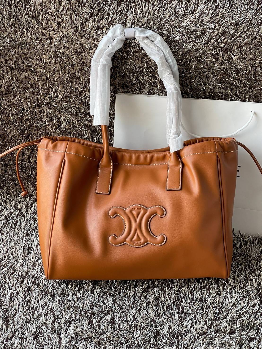 Celine cabas drawstring cuir triomphe in Smooth Calfskin / celine shopping bag เป็นกระเป๋าที่ดีไซน์คลาสสิก เรียบหรู ไม่ตกยุค โดดเด่นเพราะมีโลโก้อยู่ตรงกลาง ออกแบบมาให้ใส่ของใช้ในชีวิตประจำวัน ซึ่งคุณสามารถใช้เป็นกระเป๋าถือหรือสะพายไหล่ก็ล้วนเก๋และมีความคล