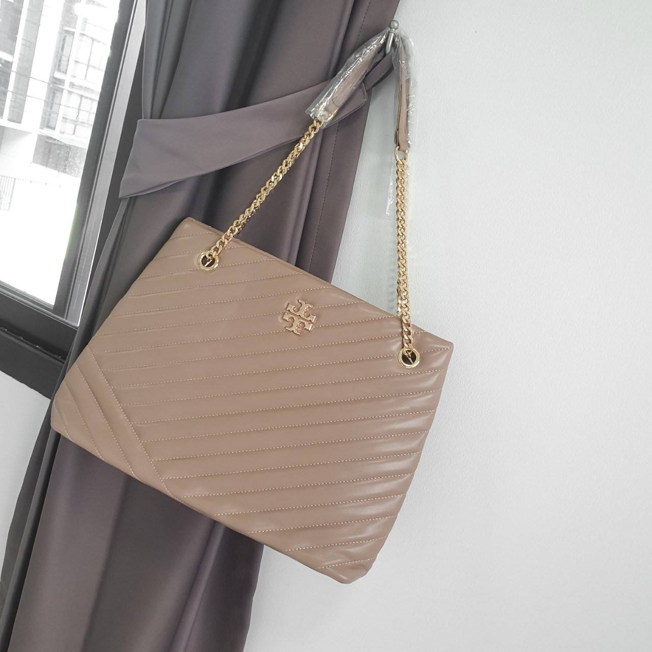 Tory Burch Kira chevron tote bag กระเป๋าทรง Tote สุดหรู ใบใหญ่ จุของได้เพียบ! วัสดุหนังแท้(Geniune Leather) หนังนิ่ม นุ่มมือมากกก มาพร้อมสายสะพายไหล่ต่อโซ่สลับหนัง อะไหล่ทองทั้งใบ ด้านข้างมีกระเป๋าเพิ่มทรงได้ ด้านในเปิดปิดด้วยกระดุมแม่เหล็ก มีช่องแบ่งใส่ข