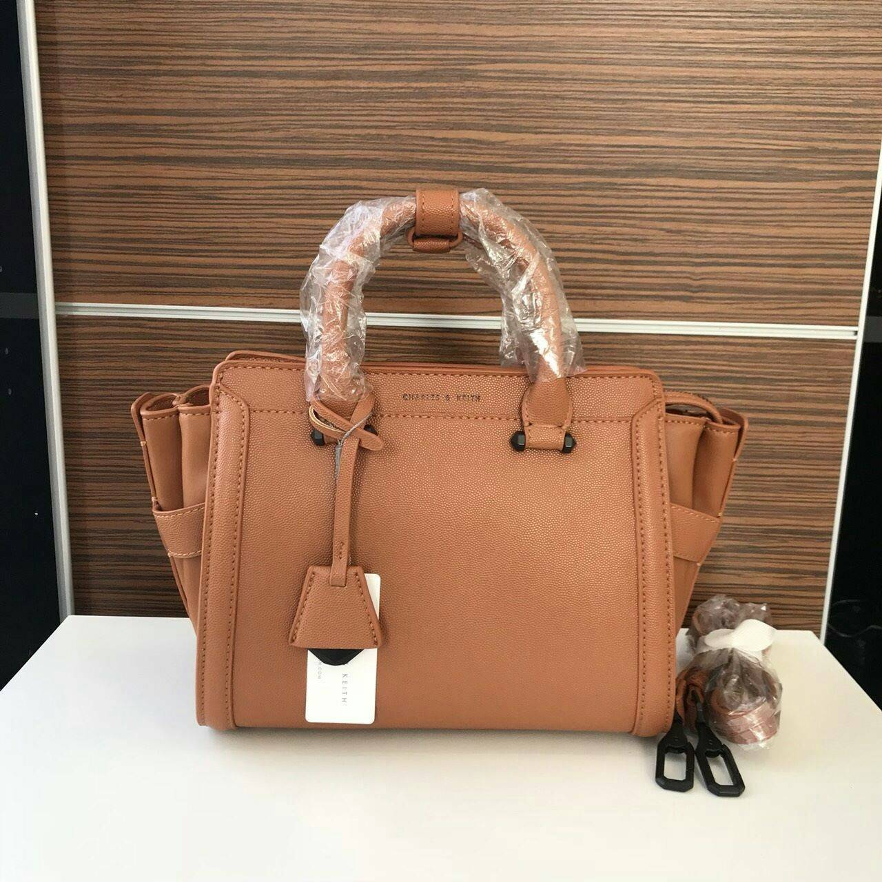 CHARLES & KEITH TRAPEZE BAG Best sellwr ! กระเป๋าถือหรือสะพายรุ่นยอดนิยมดีไซน์สวยหรูวัสดุหนัง คาเวียร์อยู่ทรง ด้านข้างเเต่งหนังช่องตัดดูมีดีเทล ด้านหน้าสกรีนโลโก้ ด้านหลังมีช่องซิป เปิดปิดด้วยซิปหัวซิป ปัํ๊มโลโก้ หูจับเเข็งแรง พับลงได้ พร้อมสายสะพายหนังปร