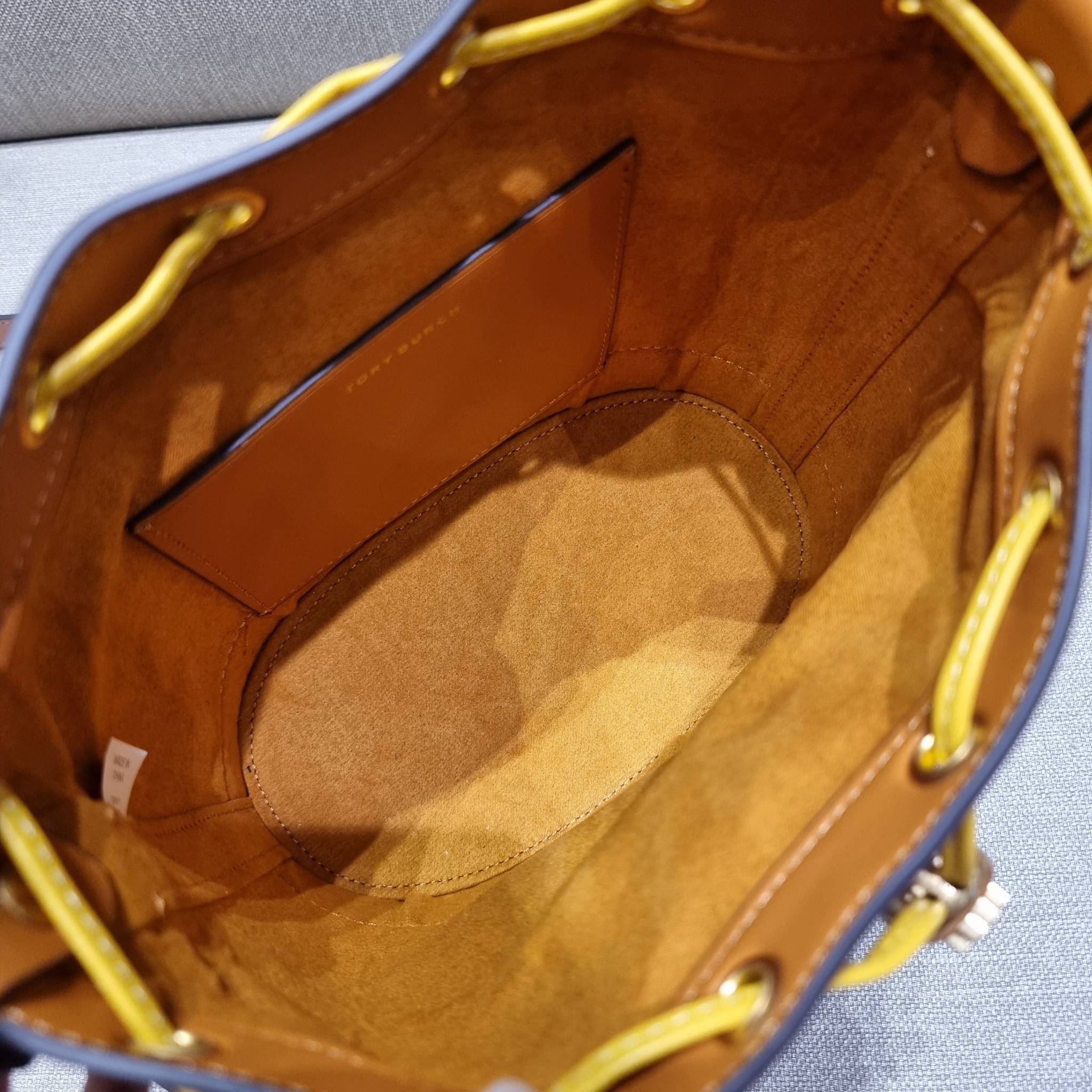 TORY BURCH T MONOGRAM COLORBLOCK JACQUARD BUCKET BAG ไอเท็มใหม่ที่ใครๆก็รอ กระเป๋าบัคเก็ตทรงสวย ที่ยังคงให้ความโดดเด่นด้วยลวดลายเอกลักษณ์ เพิ่มเติมดีไซน์บล็อคสี ตัดกันได้อย่างลงตัว ถักทอบนวัสดุ woven jacquard ลายคมชัด สลับส่วนของหนังแท้ ภายในเป็นช่องโล่งก