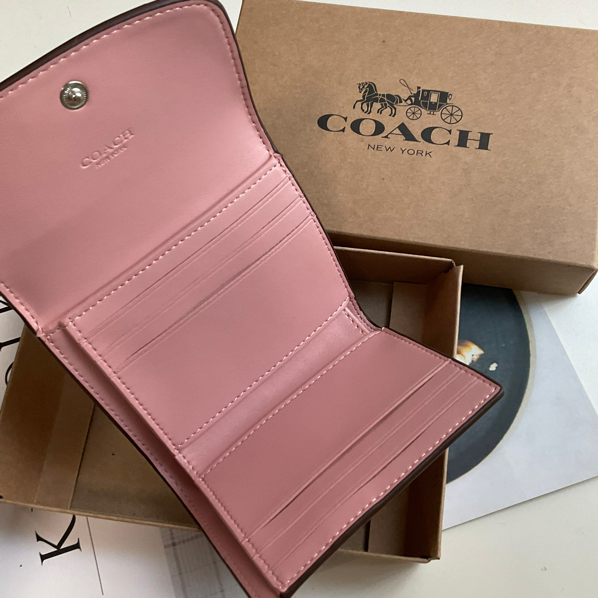 COACH SMALL WALLET IN SIGNATURE CANVAS กระเป๋าสตางค์ใบสั้น แบบพับสามตอน เปิดปิดด้วยกระดุมปั้มแบรนด์ ด้านในมีช่องใส่บัตรหลายช่อง และช่องใส่ธนบัตร ด้านหลังมีช่องซิปเหรียญอีกหนึ่งช่อง น้ำหนักเบา พกพาสะดวก อะไหล่เงาสุดหรู ห้ามพลาดค่ะ!