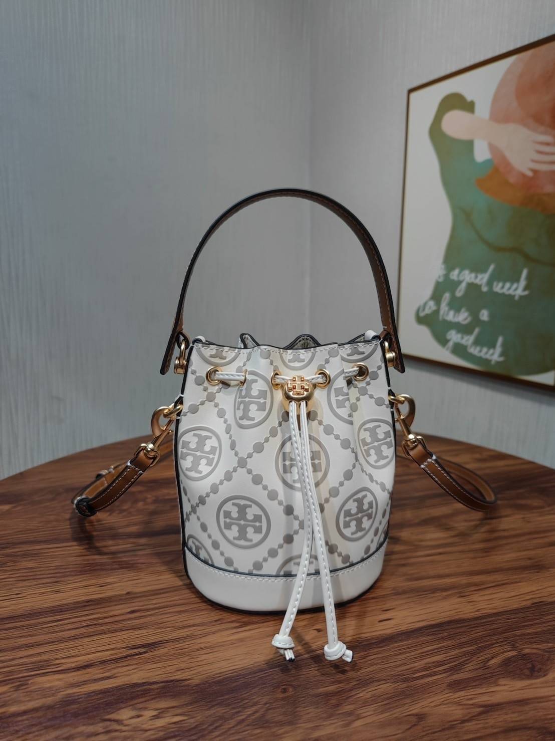 Tory Burch T Monogram Embossed Mini Bucket Bag กระเป๋าทรงถังขนาดเล็ก ประดับด้วยลวดลายอันเป็นสัญลักษณ์ของแบรนด์ ถูกประดิษขึ้นด้วยความพิถีพิถันวัสดุหนังอย่างดี ด้านในบุด้วยหนังไมโครซูแอคเนื้อนุ่มทำความสะอาดง่าย อะไหล่ทองหรูหรา มาพร้อมสายยาว ปรับสายได้ ถอดสา