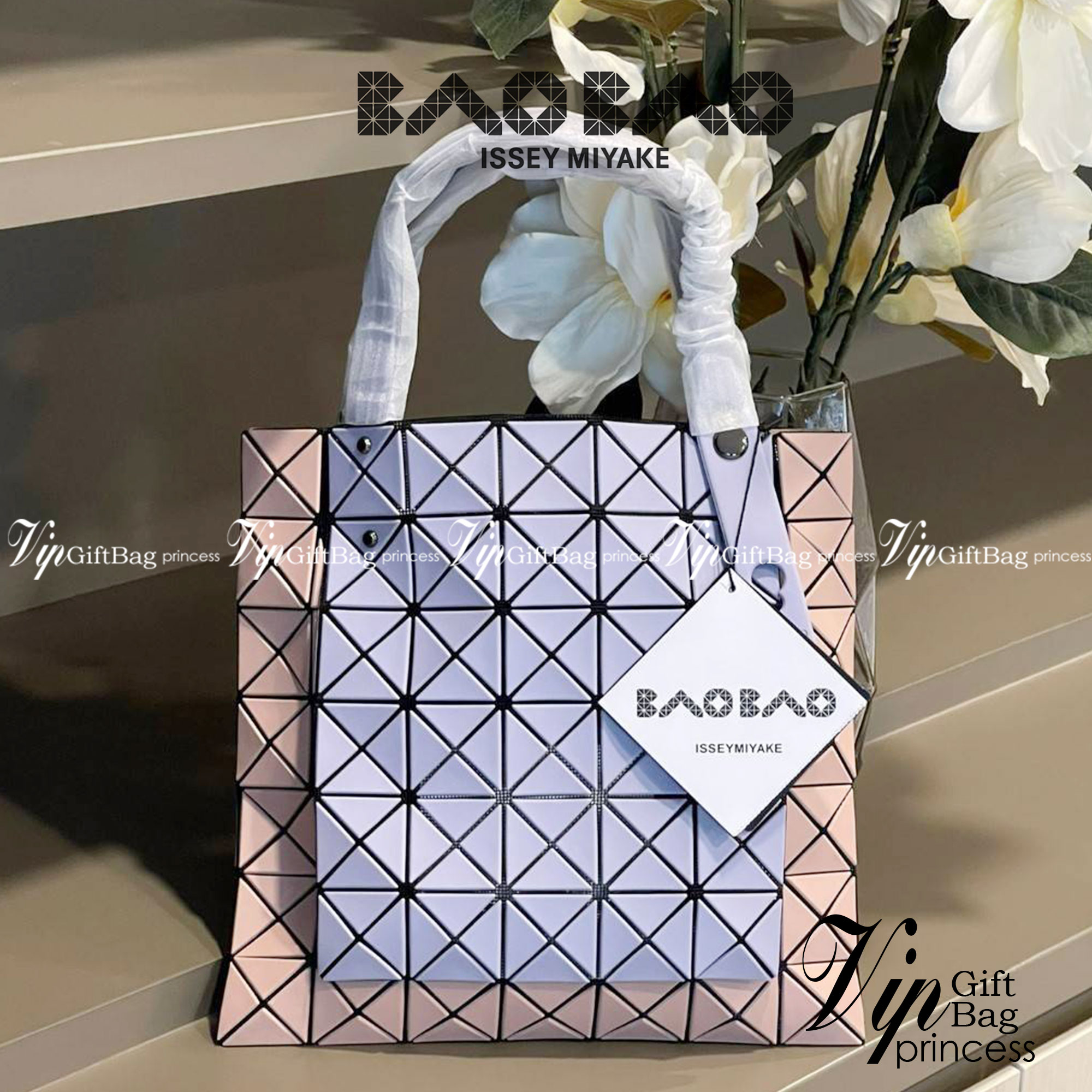 Baobao Issey Miyake Prism Kangaroo tote bag กระเป๋าถือทรงโท้ทที่ประดิษฐ์ขึ้นอย่างเชี่ยวชาญในญี่ปุ่น มาพร้อมแผงเรขาคณิตสำหรับการออกแบบที่ได้รับแรงบันดาลใจจากกระดาษพับ ซิลลูเอทอันเป็นเอกลักษณ์นี้ปิดท้ายด้วยสายรัดแบบอสมมาตร มีการพัฒนาโครงสร้างทรงสามเหลี่ยมเพ