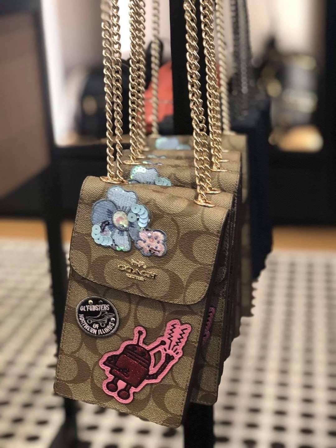 COACH NORTH/SOUTH PHONE CROSSBODY IN SIGNATURE CANVAS F55636 F39955 สุดคลาสสิคกับกระเป๋าสะพายเอนกประสงค์ Case phone ใส่โทรศัพท์มือถือได้ทุกรุ่น ดีไซน์ลายเอกลักษณ์ วัสดุหนังแคนวาสเคลือบลาย ฝาและภายในเป็นหนังสังเคราะห์เรียบ เปิด-ปิดด้วยกระดุม สายสะพายยาวประ