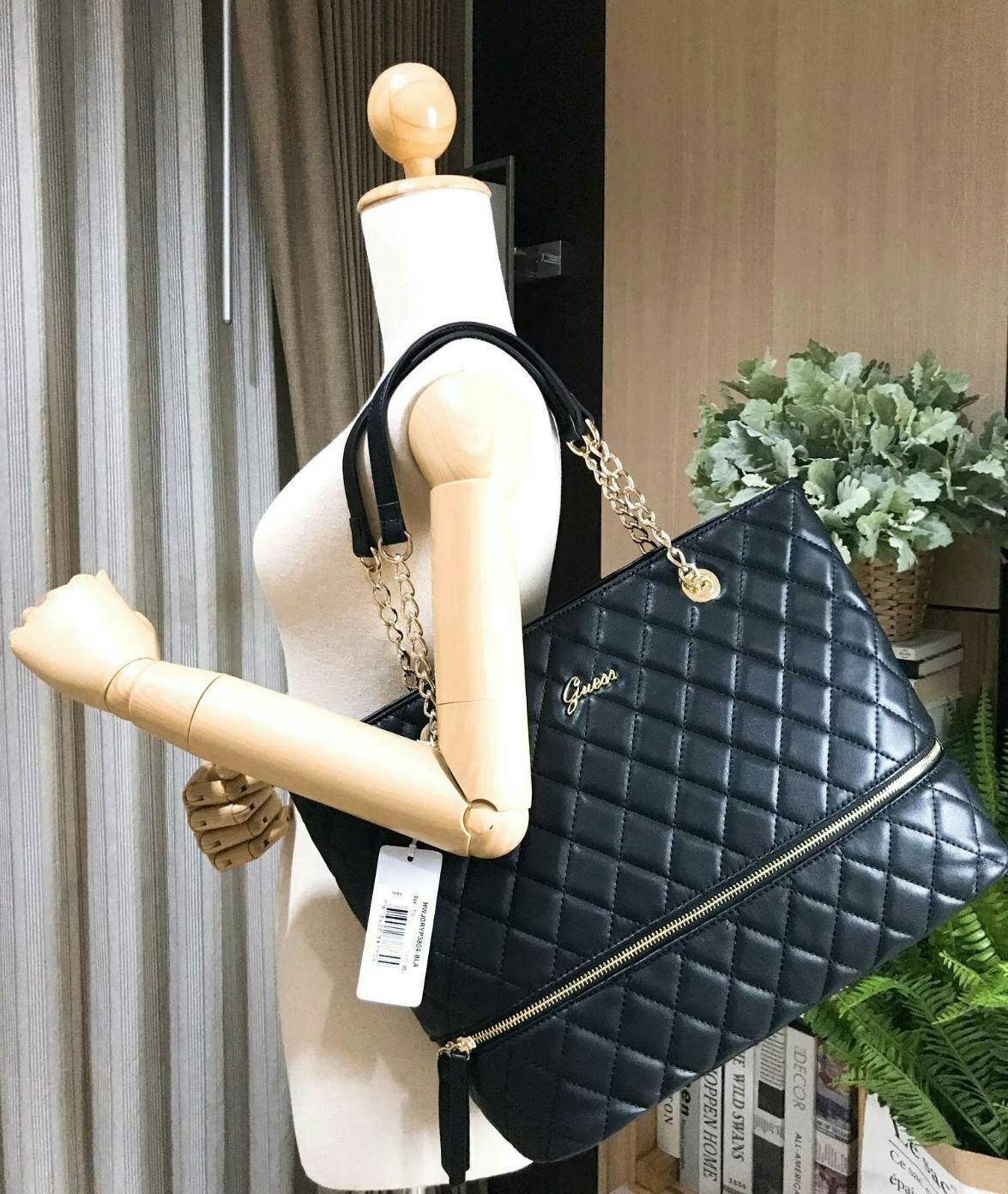 GUESS WOMEN’S SHOPPER BAG WITH ZIPS (SIZE L) กระเป๋าสะพายรุ่นใหม่ล่าสุดจาก GUESS FACTORY ลายตารางข้าวหลามตัดหนังนิ่มสวยอยู่ทรงไม่ย้วยขนาดใหญ่กำลังดี ด้านหน้าประดับโลโก้ พร้อมแต่งซิปดูมีดีเทล หูหิ้วสะพายไหล่โซ่ต่อหนังเเข็งแรงรับน้ำหนักได้เยอะ เปิดปิดด้วยซิ