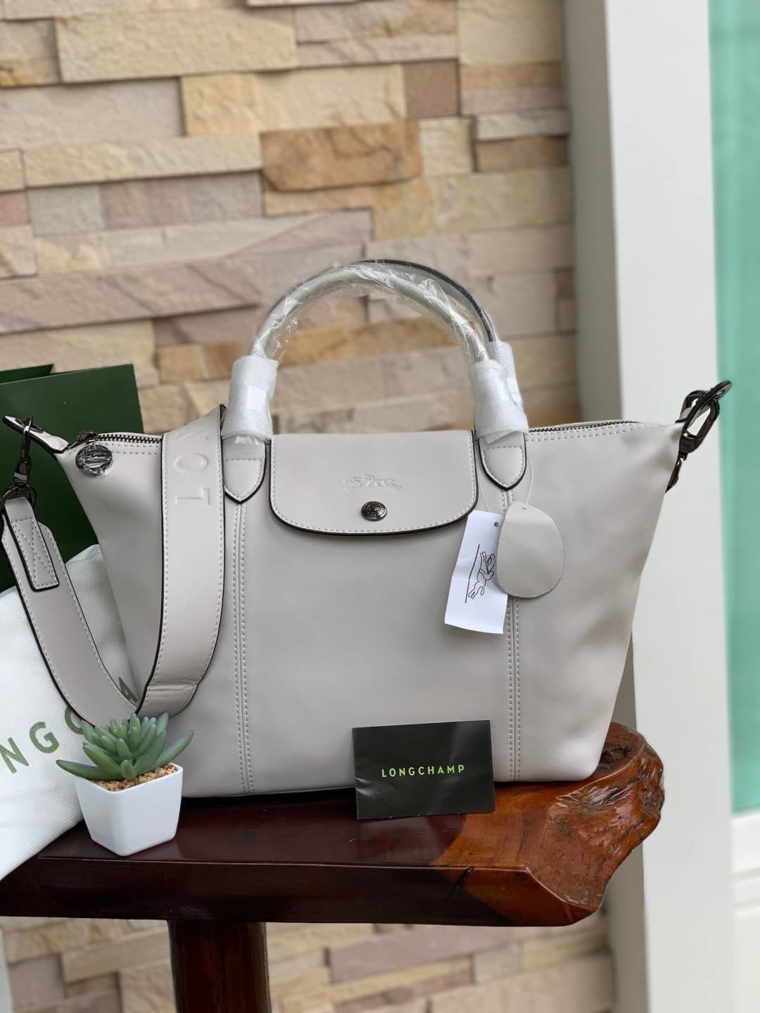 Longchamp LE PLIAGE CUIR TOP HANDLE BAG S เรียกว่าเป็นกระเป๋าอีกหนึ่งรุ่นที่ไม่ว่ายังไงก็ฮอตฮิตและติดเทรนด์ตลอดไม่เคยเปลี่ยนกับ ทรง Le Pliage Cuir หนึ่งในตระกูลกระเป๋าสุดไอคอนิกจากแบรนด์ เมื่อรุ่น Le Pliage Cuir ในรูปแบบของหนังแกะ Metis ได้ถือกำเนิดขึ้นใน