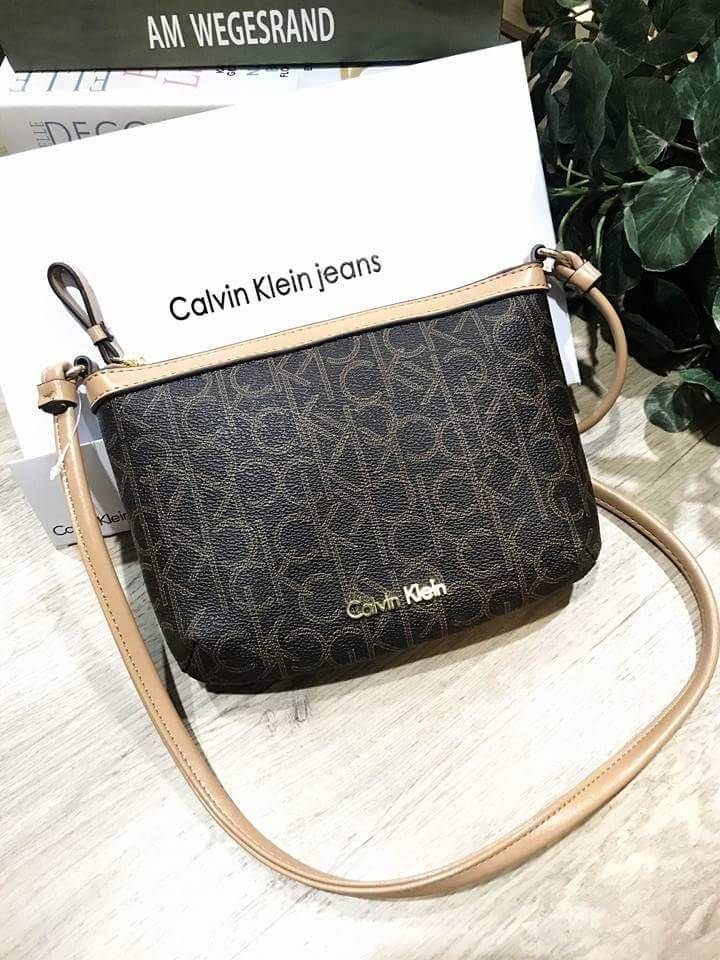 Calvin Klein Cross Body Bag กระเป๋าสะพายรุ่นใหม่ล่าสุดหนังสวย สกรีนลาย Signature แบรนด์รอบใบ ประดับโลโก้แบรนด์ สีทองด้านหน้า เปิดปิดด้วยซิป น้ำหนักเบา ภายใน โล่งกว้าง มีช่องใส่บัตร และช่องซิป ใส่ iphone+ ได้ มาพร้อมสายสะพายยาว ขนาดกำลังน่ารัก สะพายคล่องตั