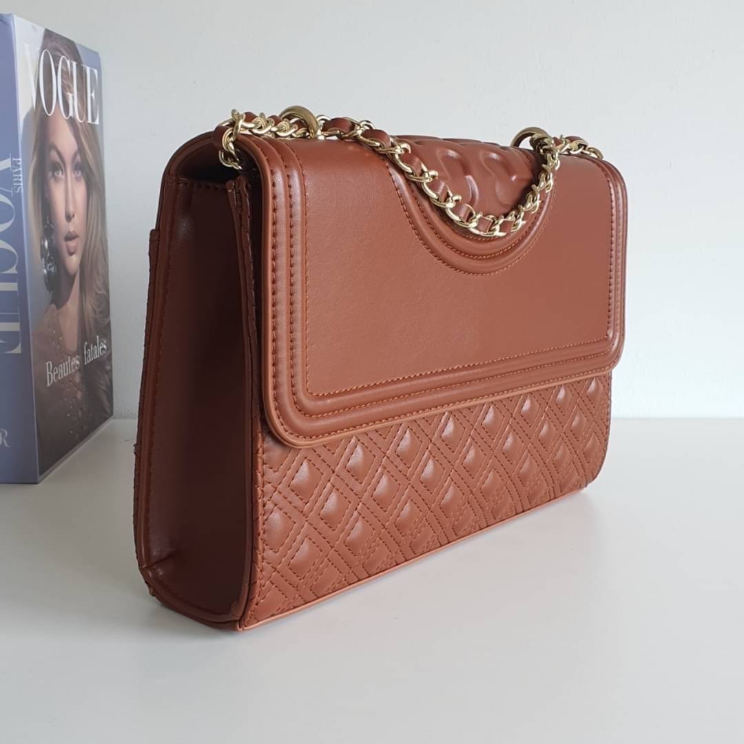 TORY BURCH Fleming Small Convertible Shoulder Bag รุ่นขายดีที่สุดกับ ไอเท็มที่ต้องมีแบรนด์ TORY BURCH มีมาให้ช้อปอีกแล้วค่ะสาวๆ กับทรง CLUCTH & CROSSBODY กระเป๋าสะพายข้างหรือสะพายเป็นครอสบอดี้ ประดับพู่ด้านข้าง