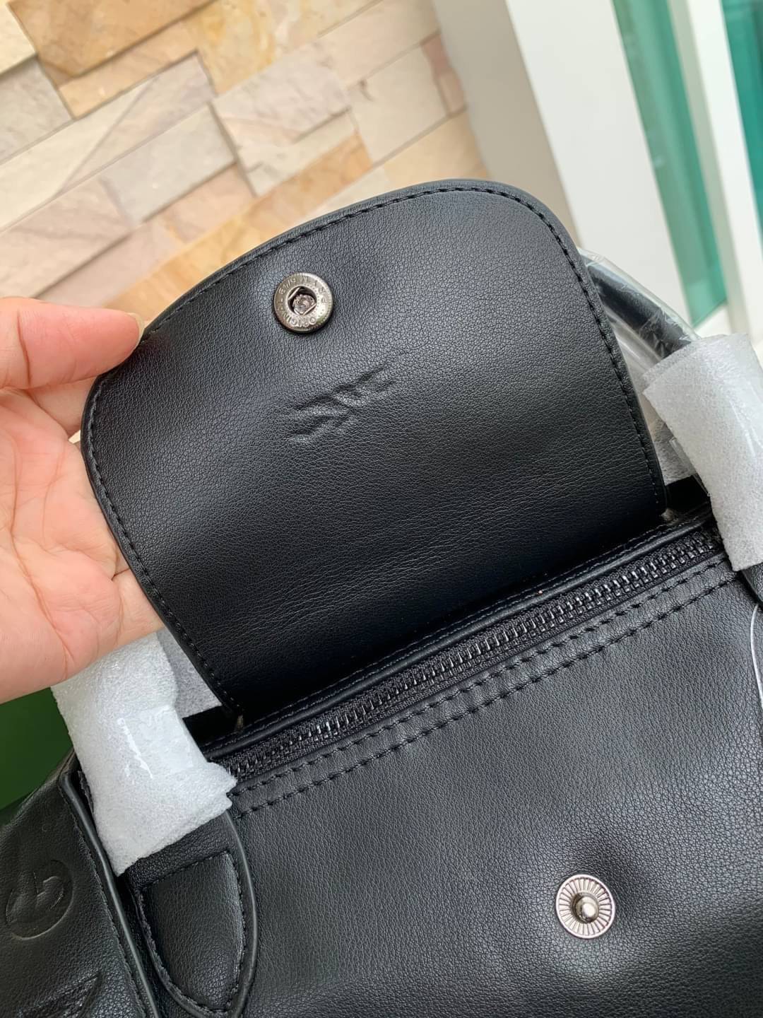 Longchamp LE PLIAGE CUIR TOP HANDLE BAG S เรียกว่าเป็นกระเป๋าอีกหนึ่งรุ่นที่ไม่ว่ายังไงก็ฮอตฮิตและติดเทรนด์ตลอดไม่เคยเปลี่ยนกับ ทรง Le Pliage Cuir หนึ่งในตระกูลกระเป๋าสุดไอคอนิกจากแบรนด์ เมื่อรุ่น Le Pliage Cuir ในรูปแบบของหนังแกะ Metis ได้ถือกำเนิดขึ้นใน