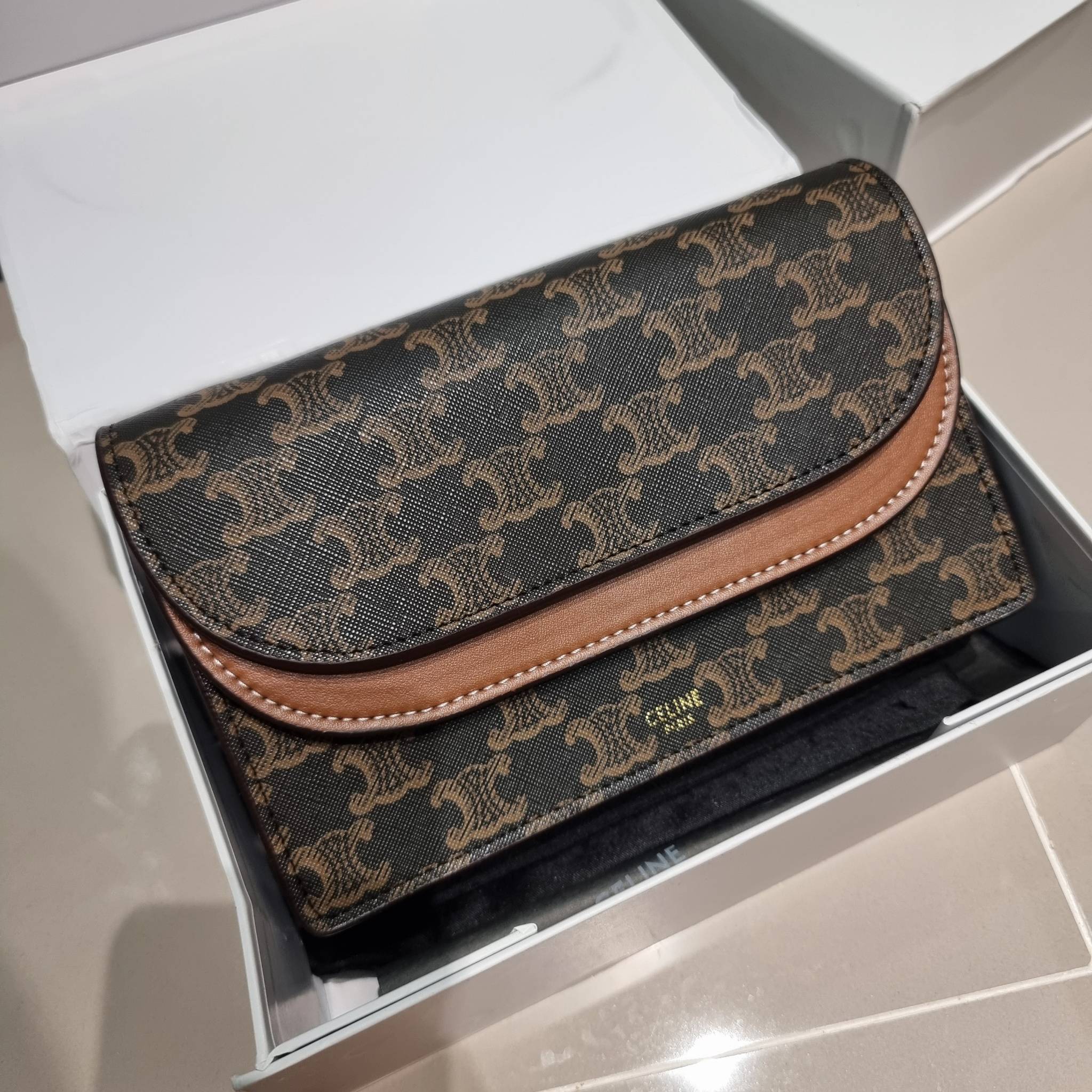 CELINE WALLET ON STRAP IN TRIOMPHE CANVAS AND LEATHER อีกหนึ่งรุ่นยอดนิยม กระเป๋าสะพายกึ่งคลัทช์ ในรูปแบบกระเป๋าสตางค์ ให้พกพาได้ง่าย ใส่ของสำคัญ มือถือ หรือบัตรต่างๆได้