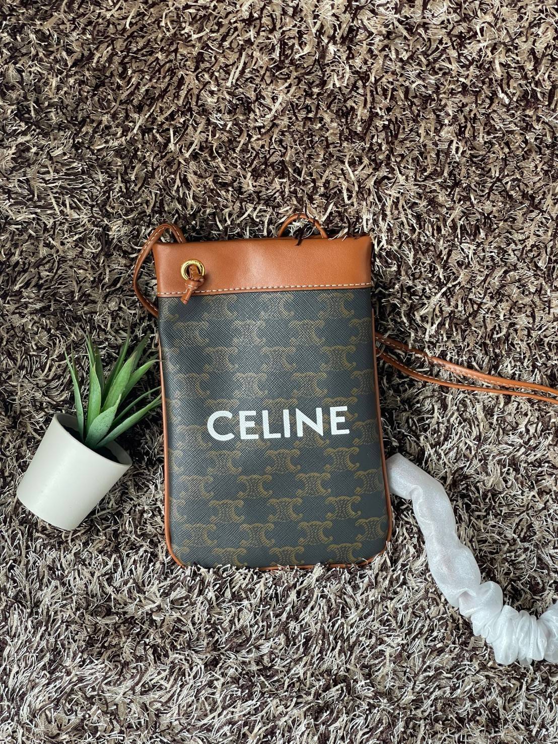 Celine Triomphe Pouch Crossbody Bag / Celine Phone Bag ในวันที่ต้องการความคล่องตัว เราสามารถหยิบกระเป๋าใส่โทรศัพท์ประเภทนี้เพื่อใส่เพียงแค่โทรศัพท์ เงิน และของสำคัญชิ้นเล็ก ๆ ได้เลย โดยไม่ต้องพกกระเป๋าใบใหญ่ ๆ ไปให้เกะกะ แถมยังดูเป็นแฟชั่นที่ทันสมัยอีกด้ว